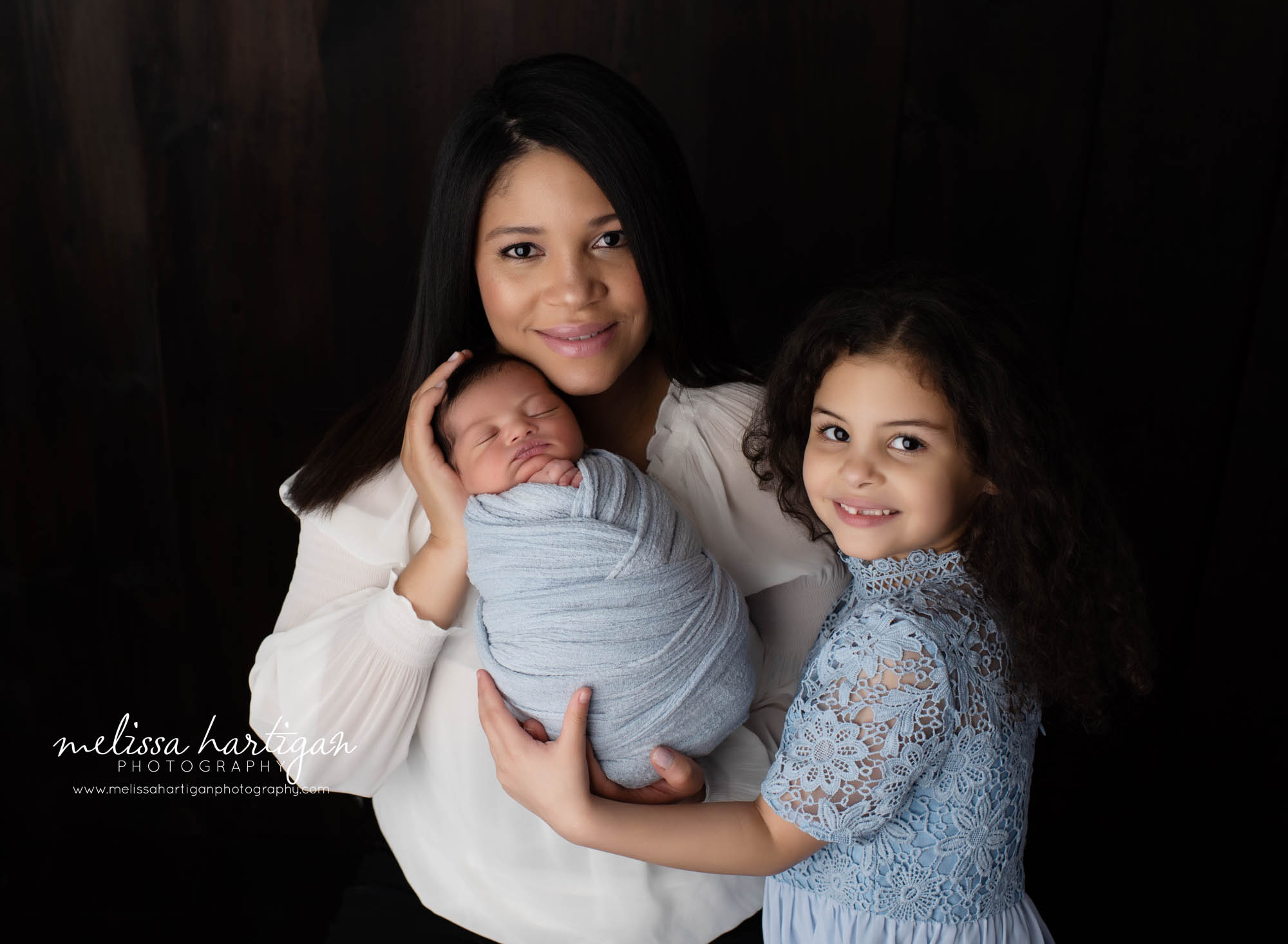 Newborn baby boy with mom and older sister studio photography session pose