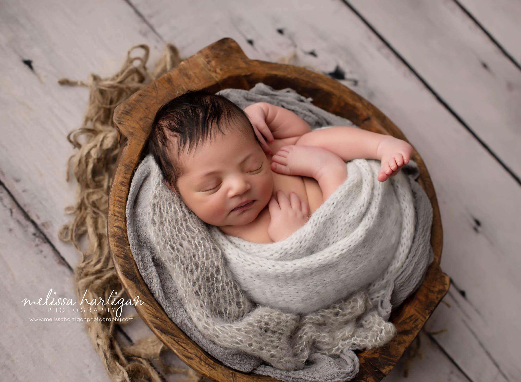 Baby boy posed in wooden bowl with light gray knitted wrap newborn photography CT studio session