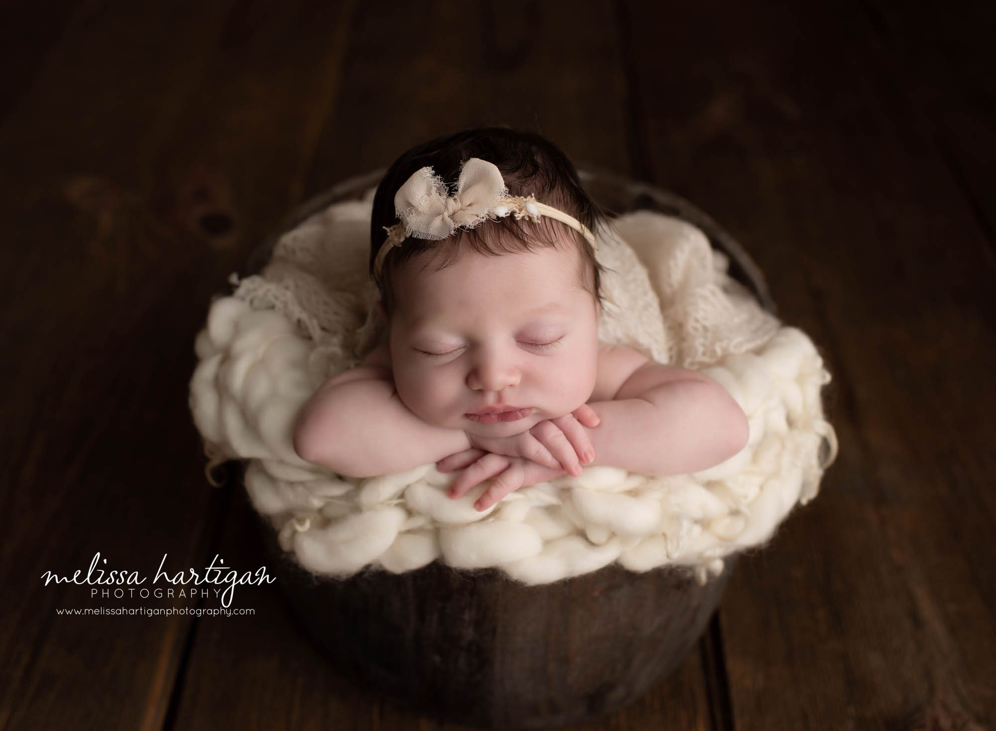 Baby girl posed in bucket with cream layers and cream bow headband Columbia CT Newborn Photographer
