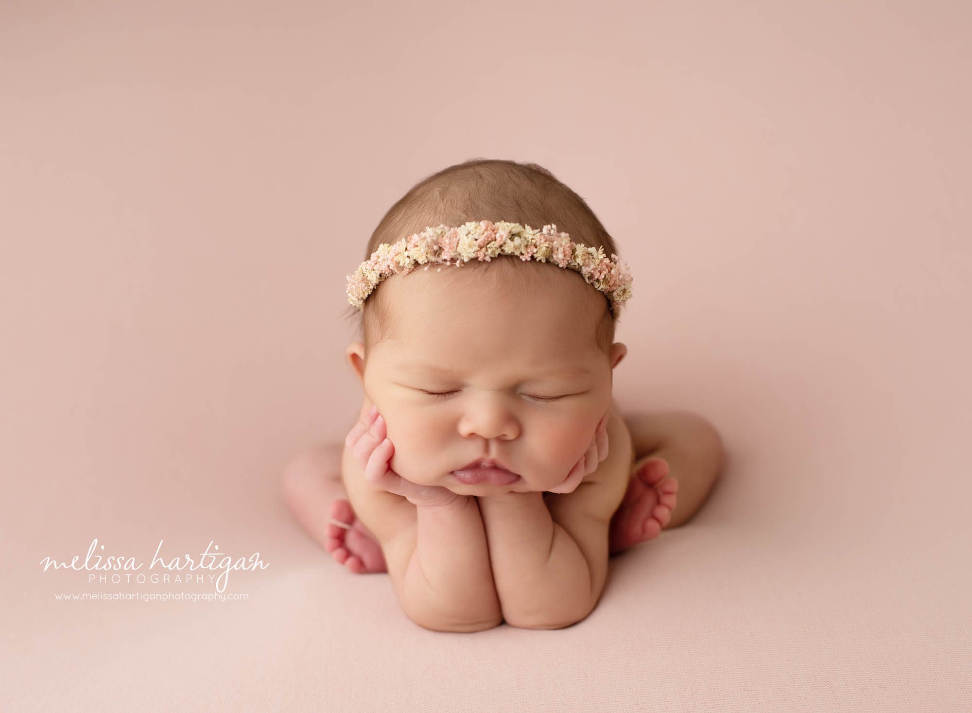 baby girl posed froggy pose on pink backdrop newborn photography