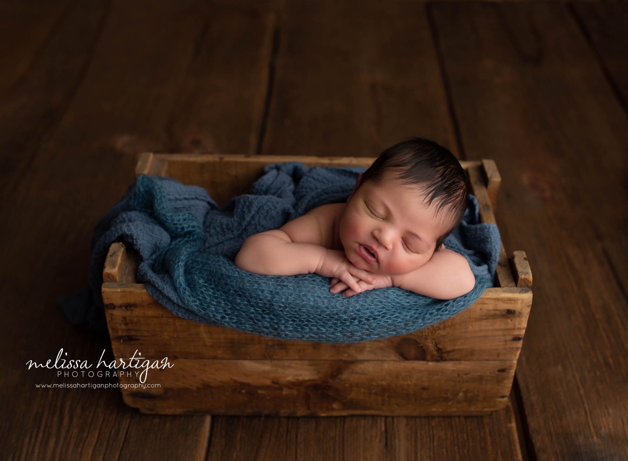 baby boy posed in wooden crate with blue knitted wrap Waterbury CT newborn photographer