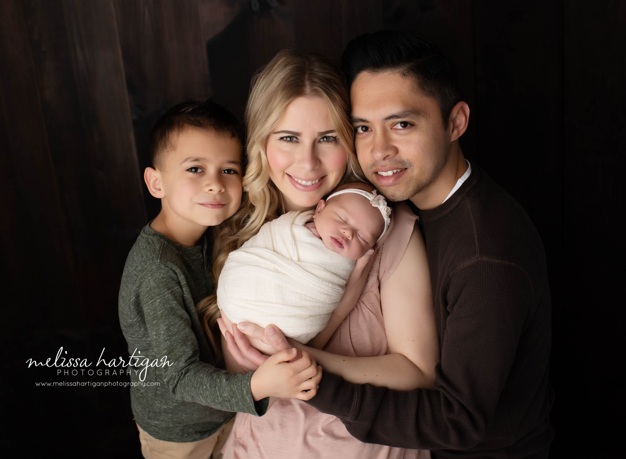 mom dad newborn baby girl and older brother in newborn session family photo pose