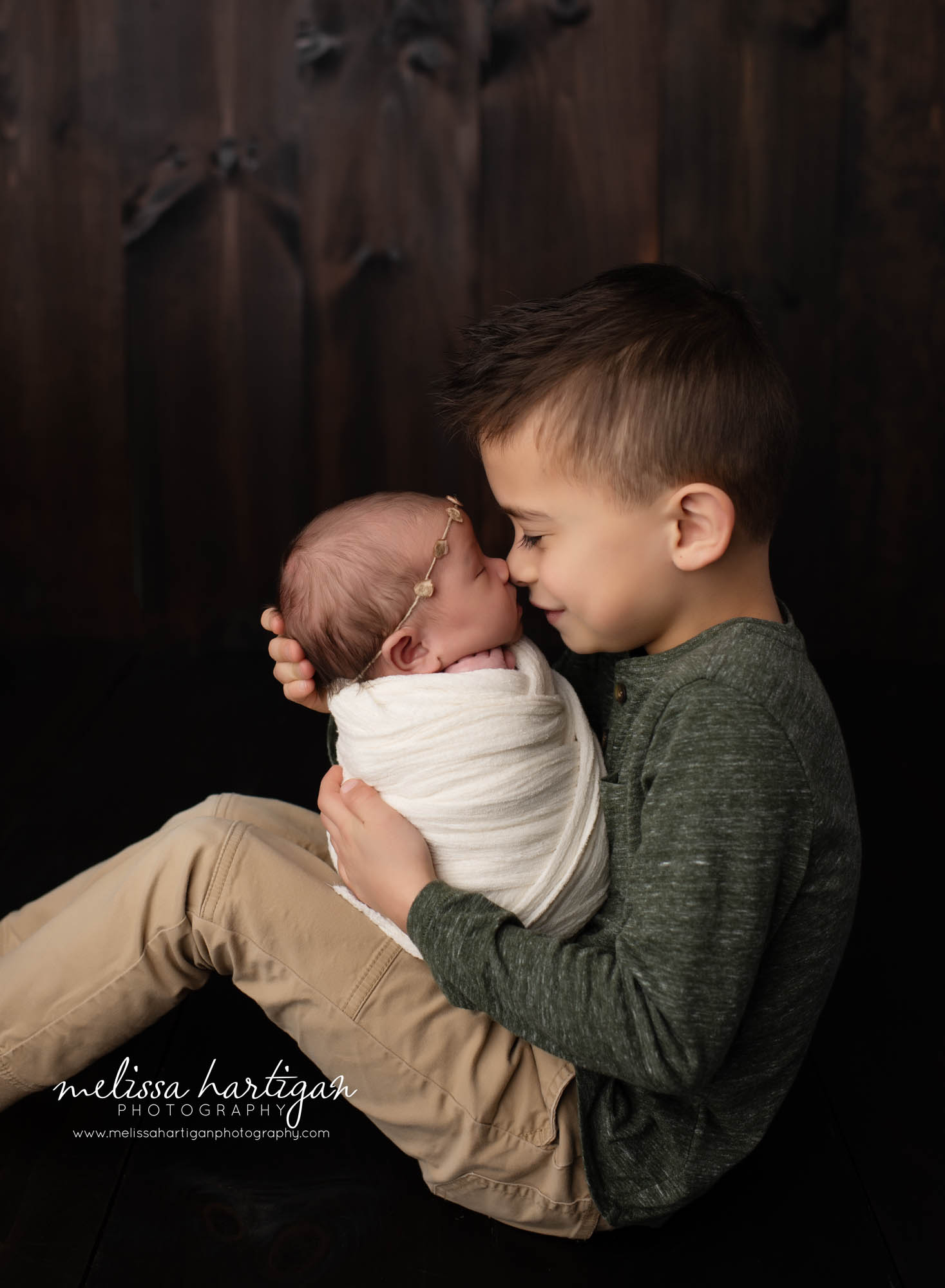 older brother giving love nose to nose with new baby sister