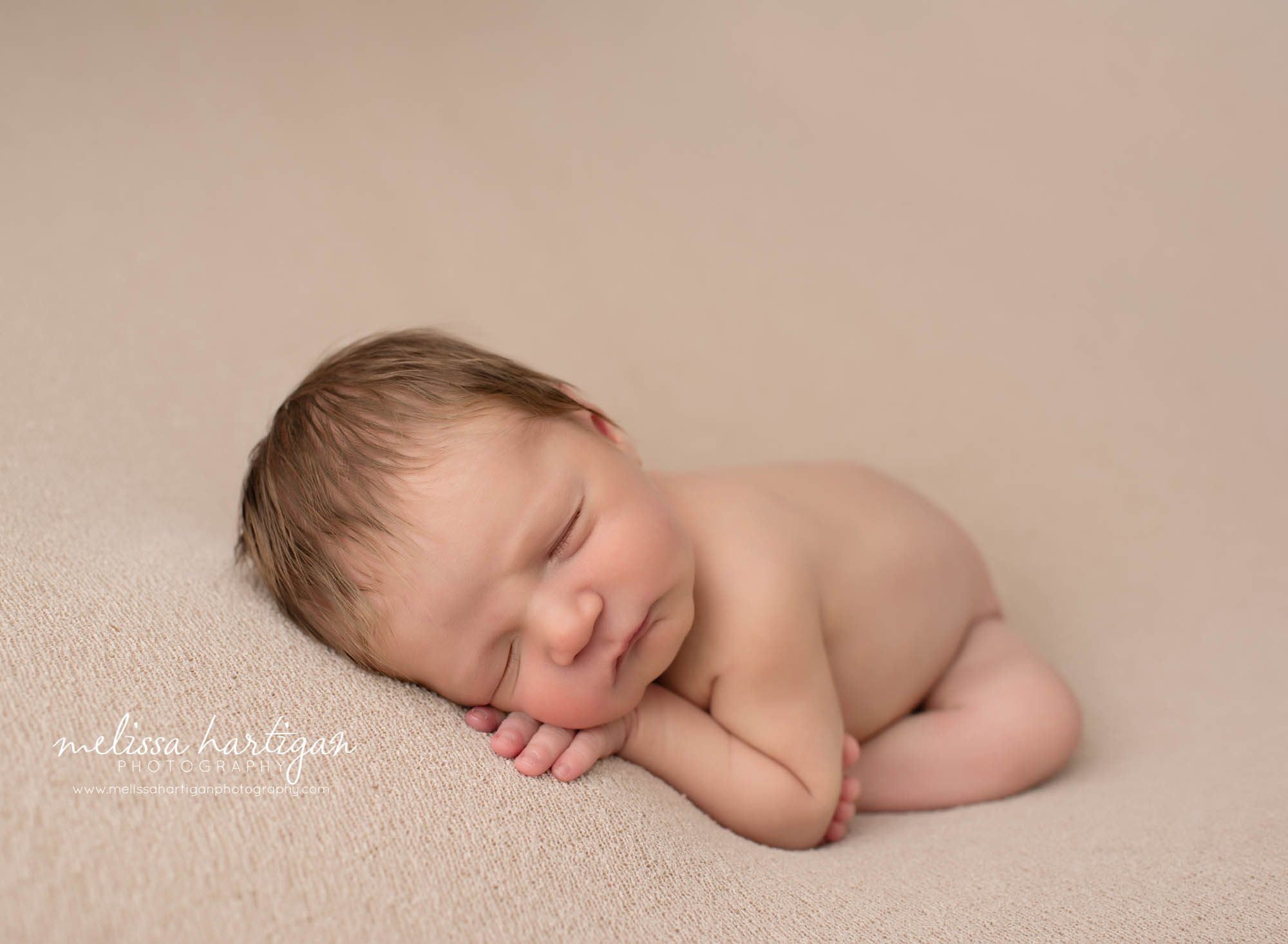 baby boy posed on tan backdrop CT newborn photographer