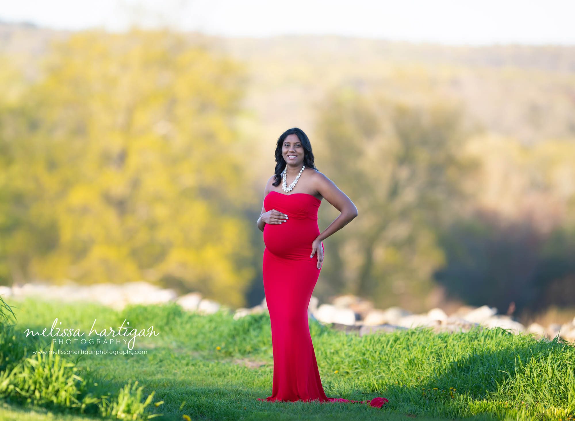 expectant mom holding baby bump wearing long red dress Ct maternity photography