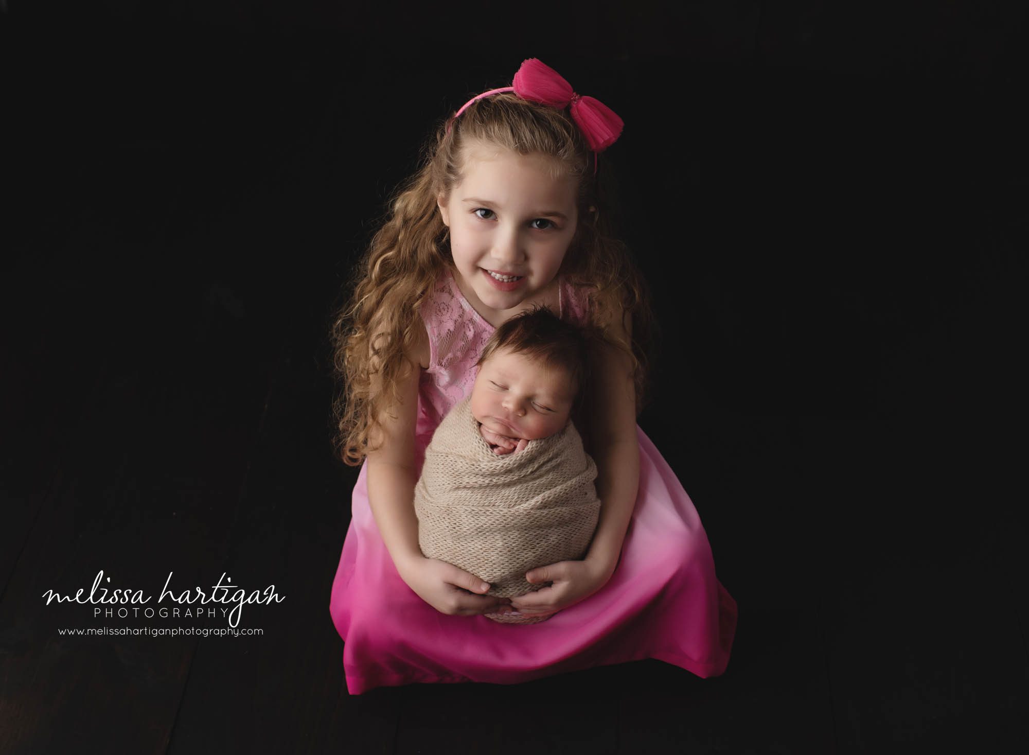 older sister holding baby brother in newborn photoshoot studio pose Newborn photography CT