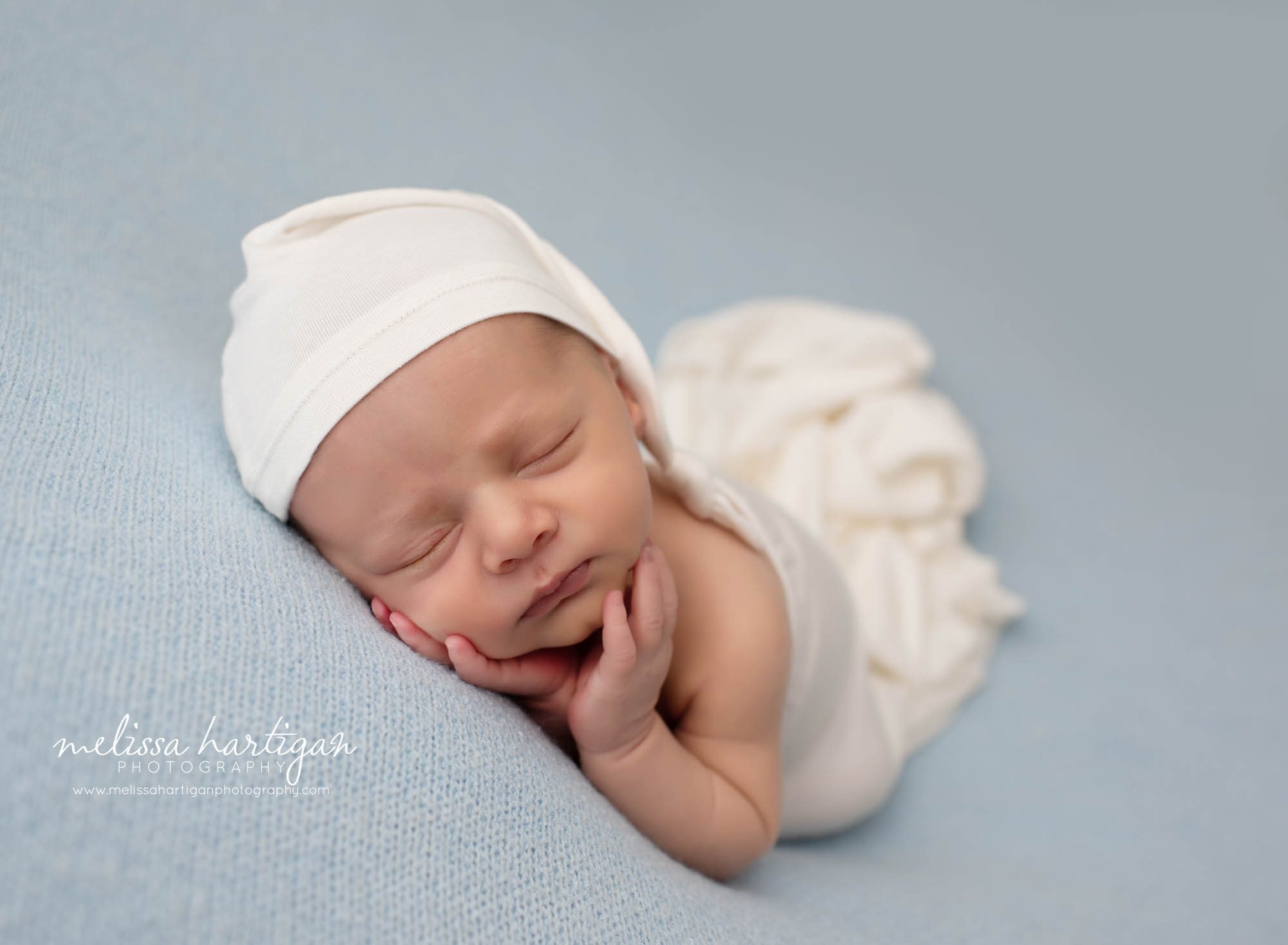 Baby boy posed on side with cream sleepy cap and wrap Newborn Photographer CT