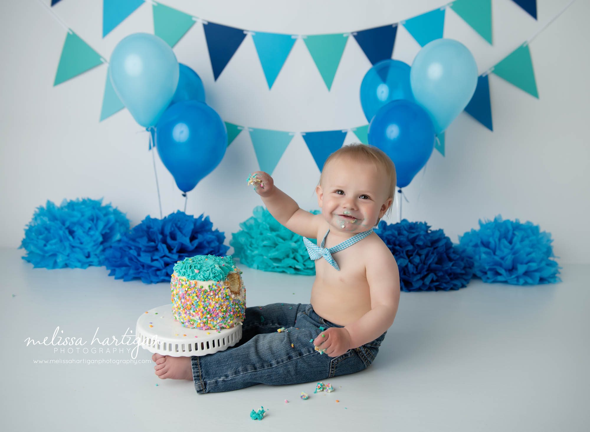 baby boy getting into his birthday cake in studio photo session CT baby milestone photographer