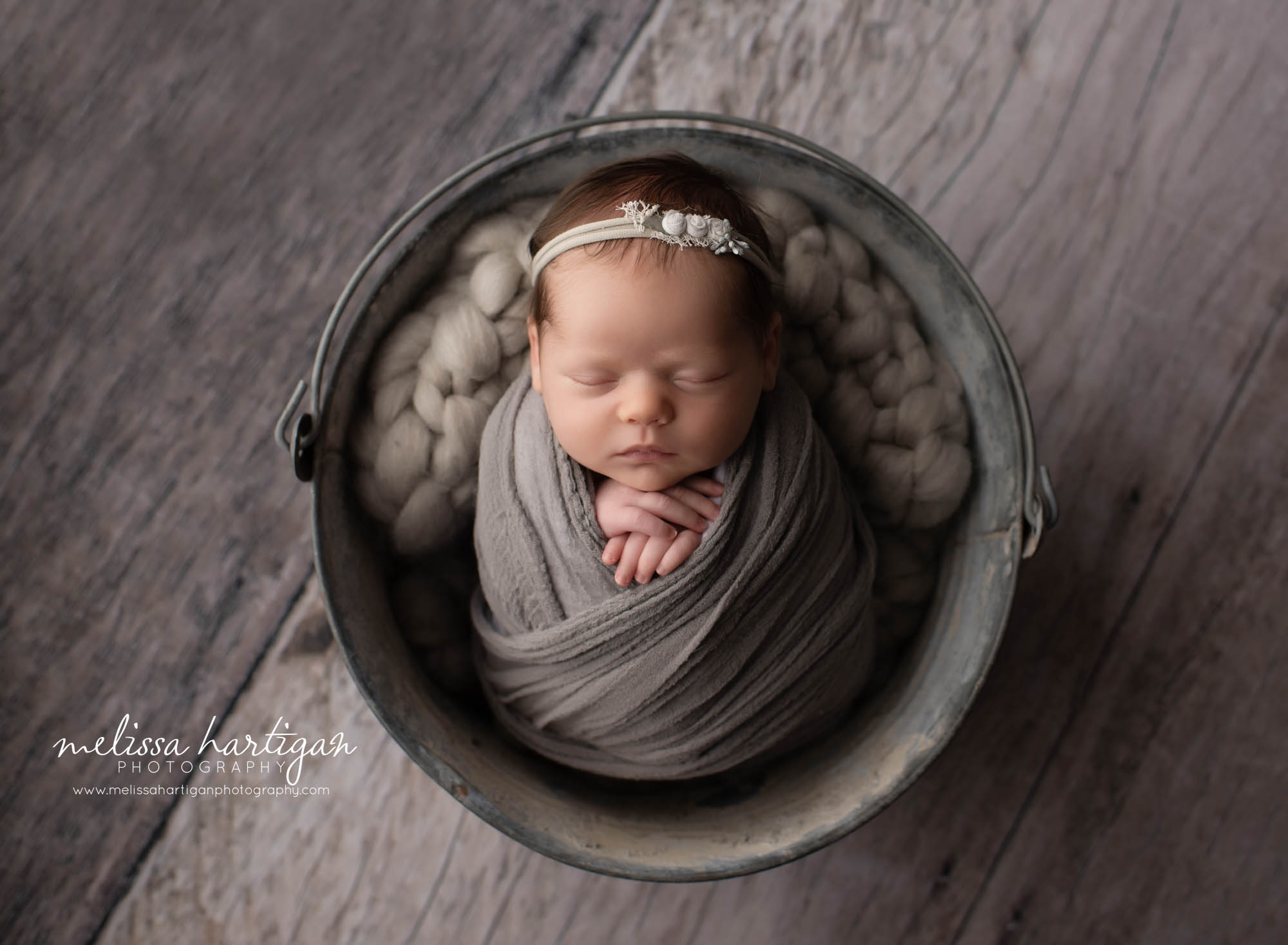 baby girl wrapped in grey wrap with flower pink headband Connecticut Newborn Photographer