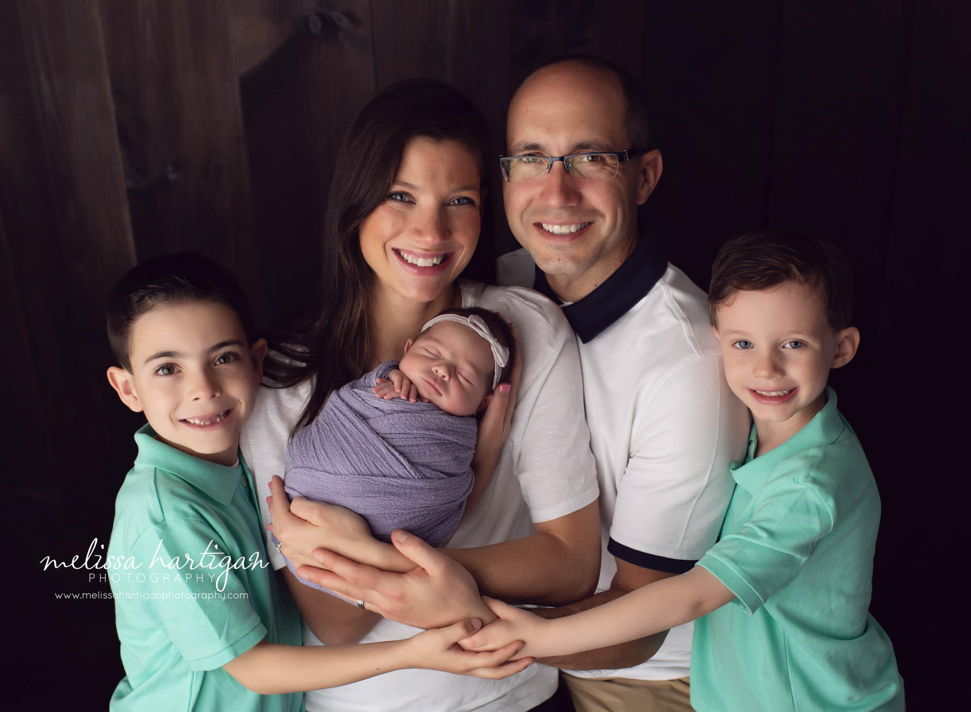family photo studio newborn session with mom dad two big brothers and baby girl