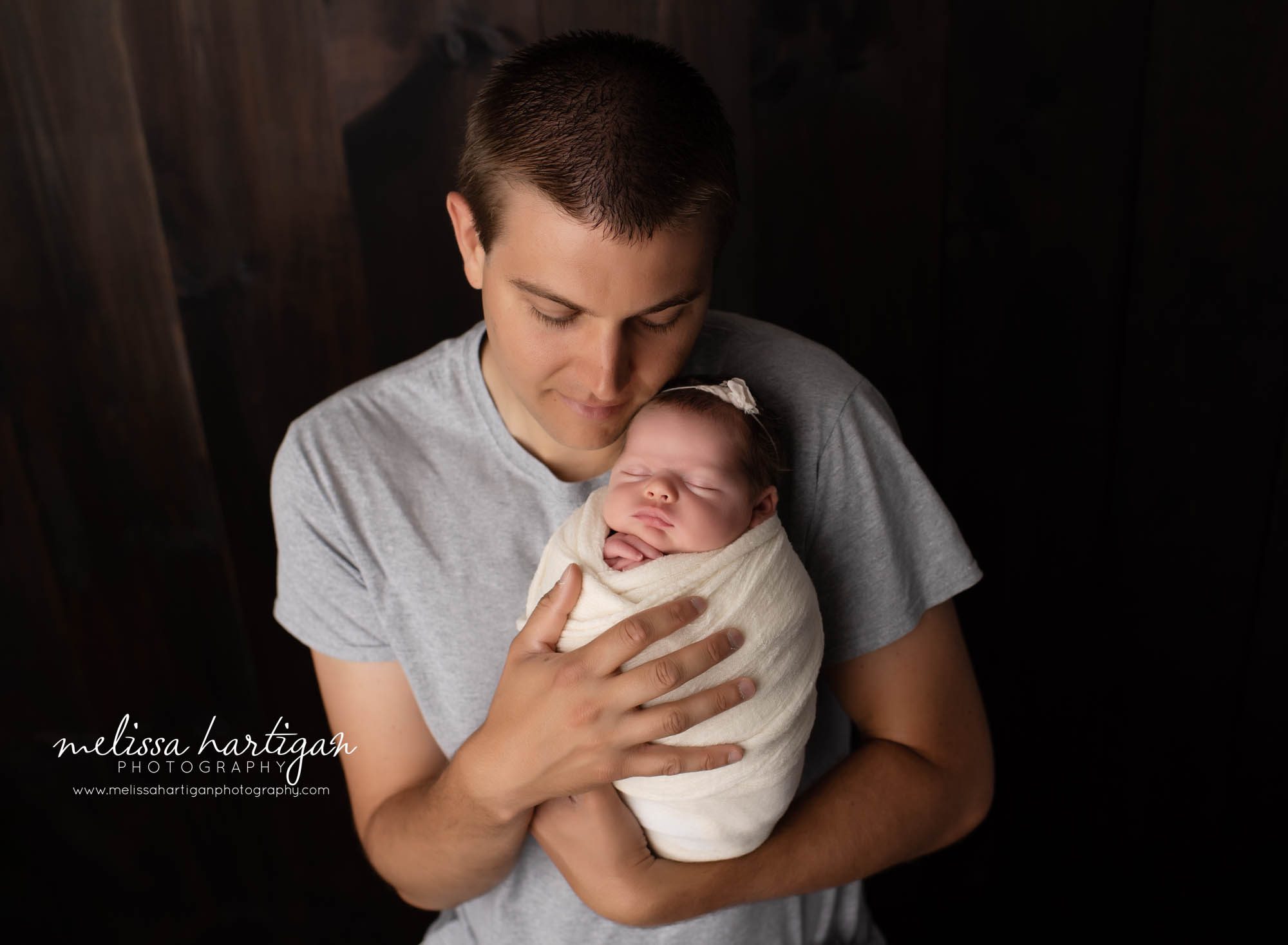 Dad holding baby girl in studio newborn session