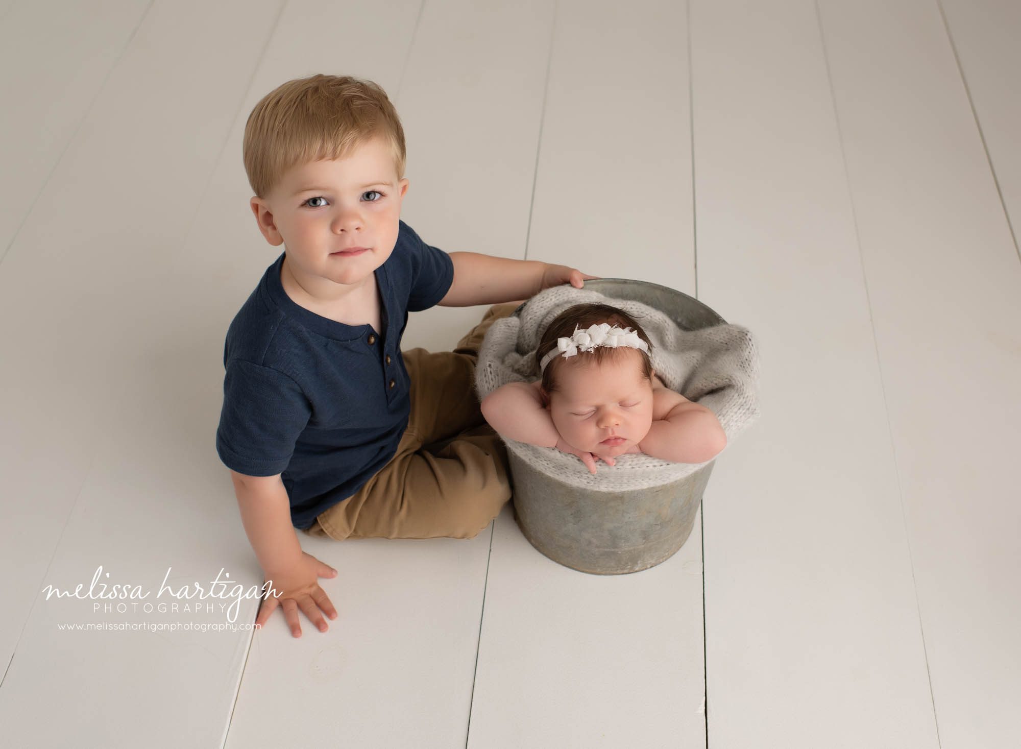 baby girl posed in bucket with toddler older brother sitting beside her CT newborn photography