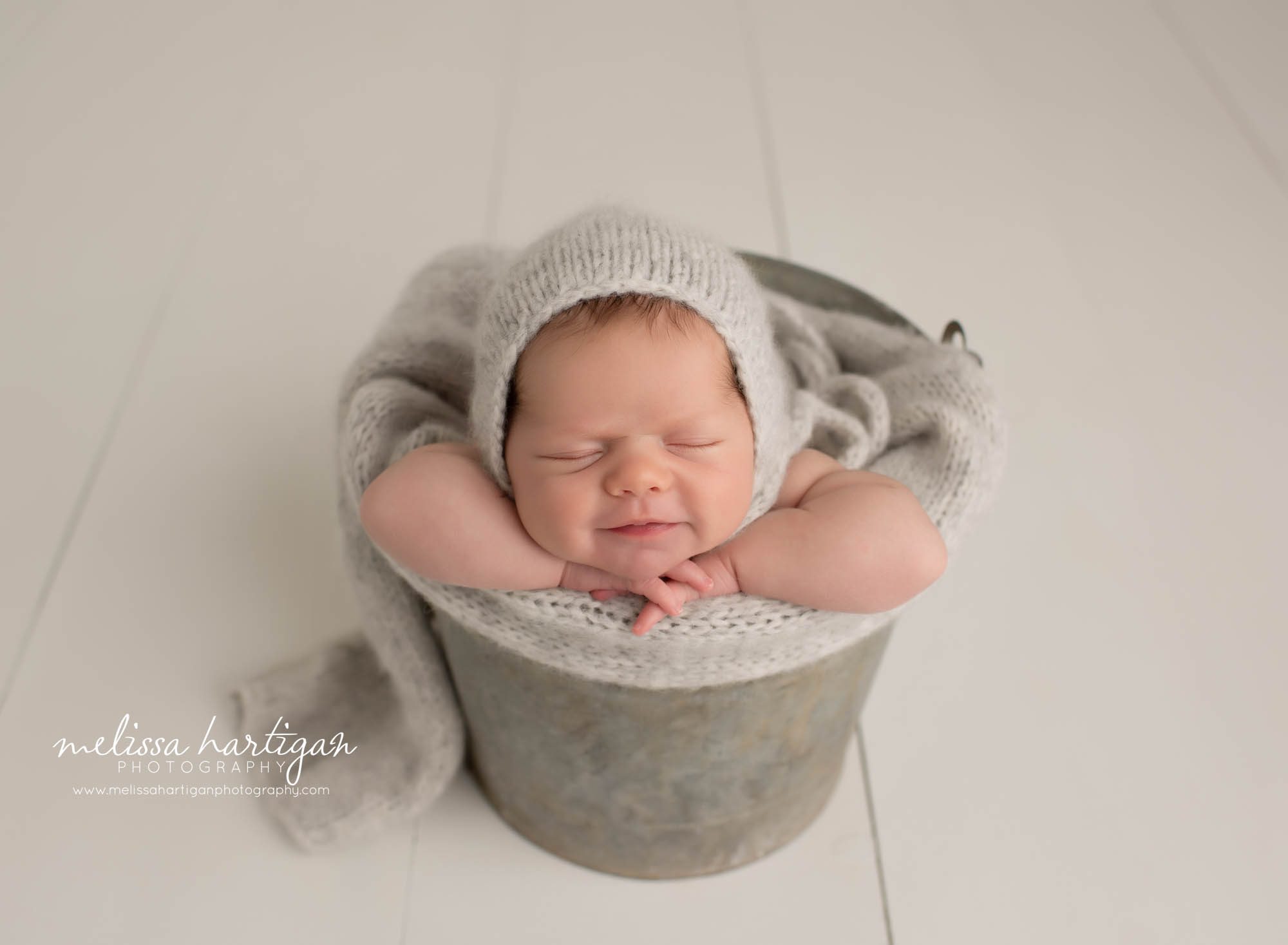 baby girl posed in metal bucket with chin on hands