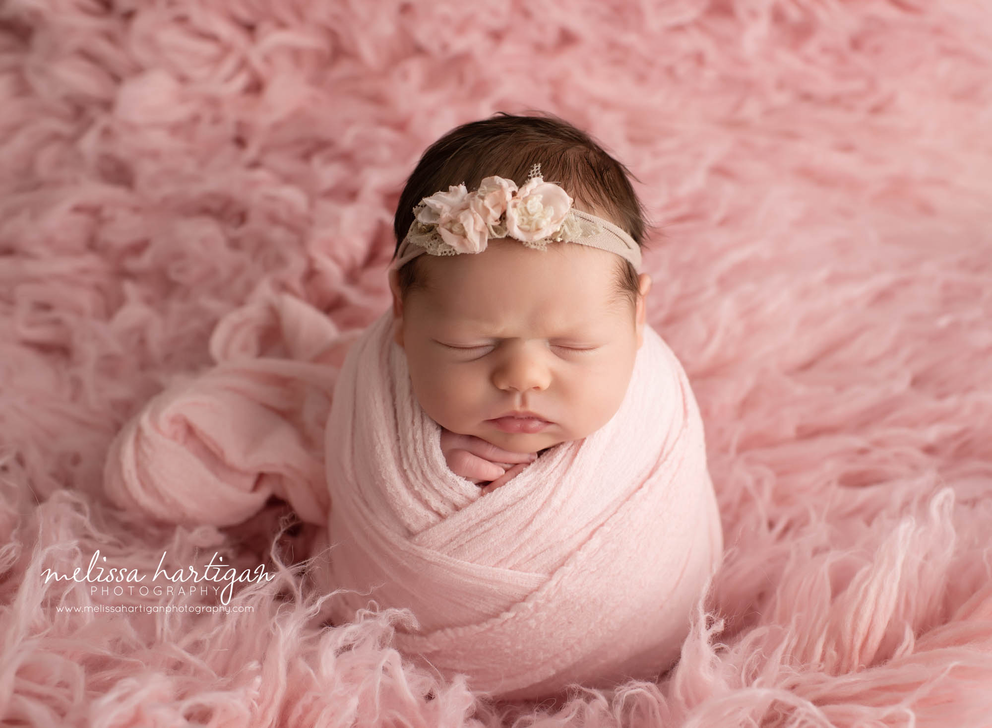 baby girl wrapped in pink wrap on blush pink flokati Connecticut newborn photographer