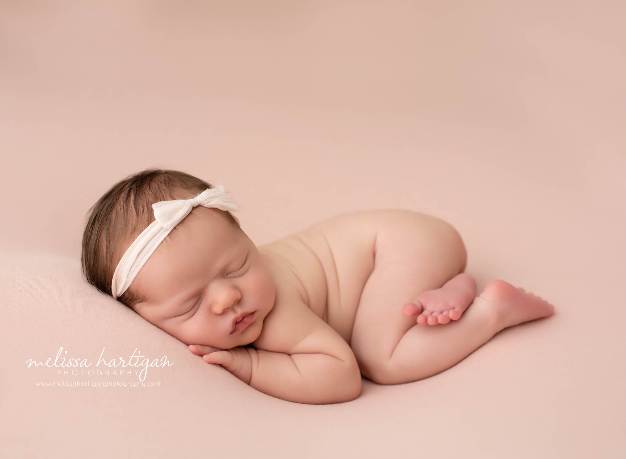 newborn baby girl posed bum up with bow headband Newborn Photography Connecticut
