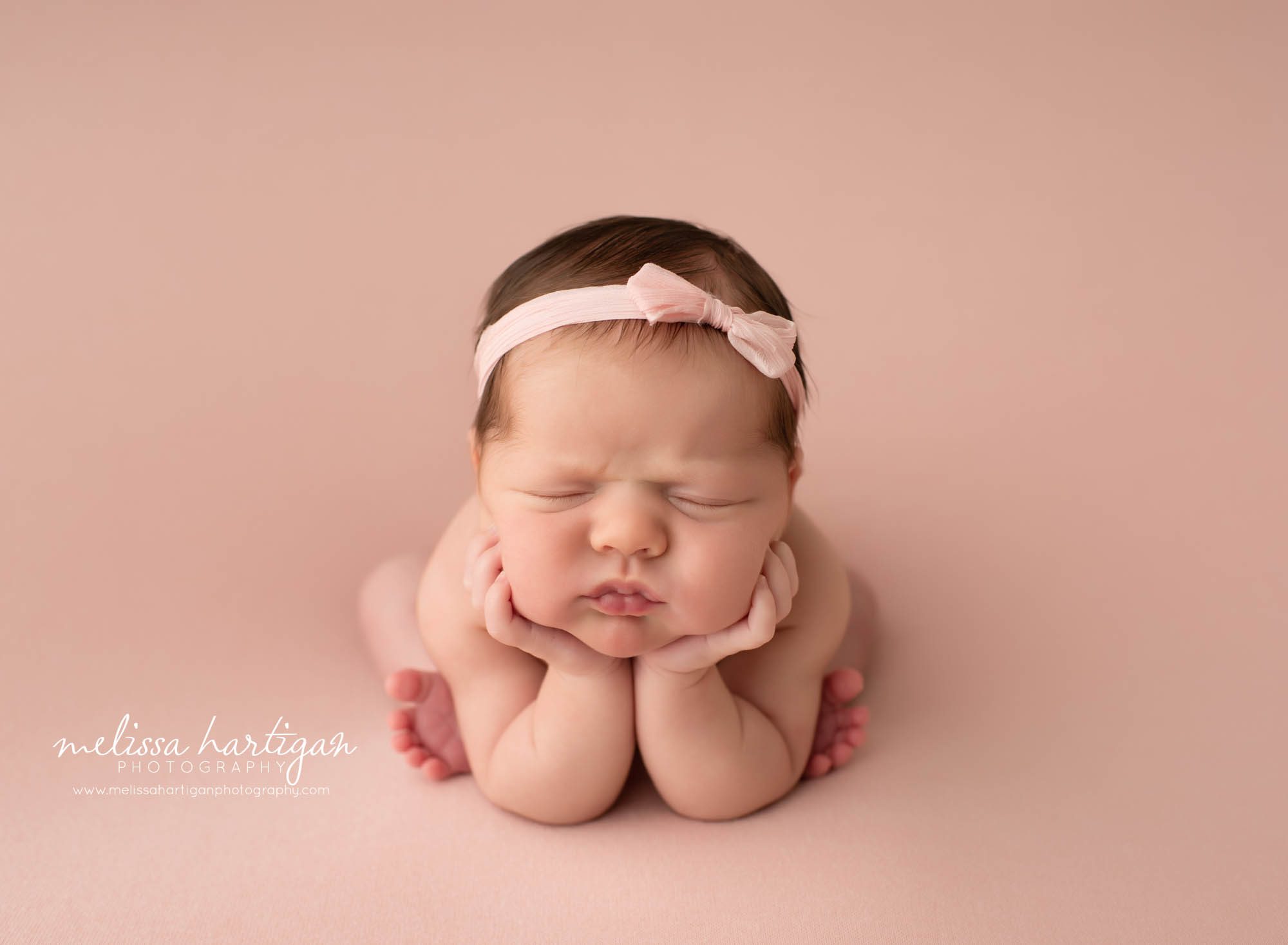 baby girl posed froggy pose wearing pink bow headband CT newborn photography