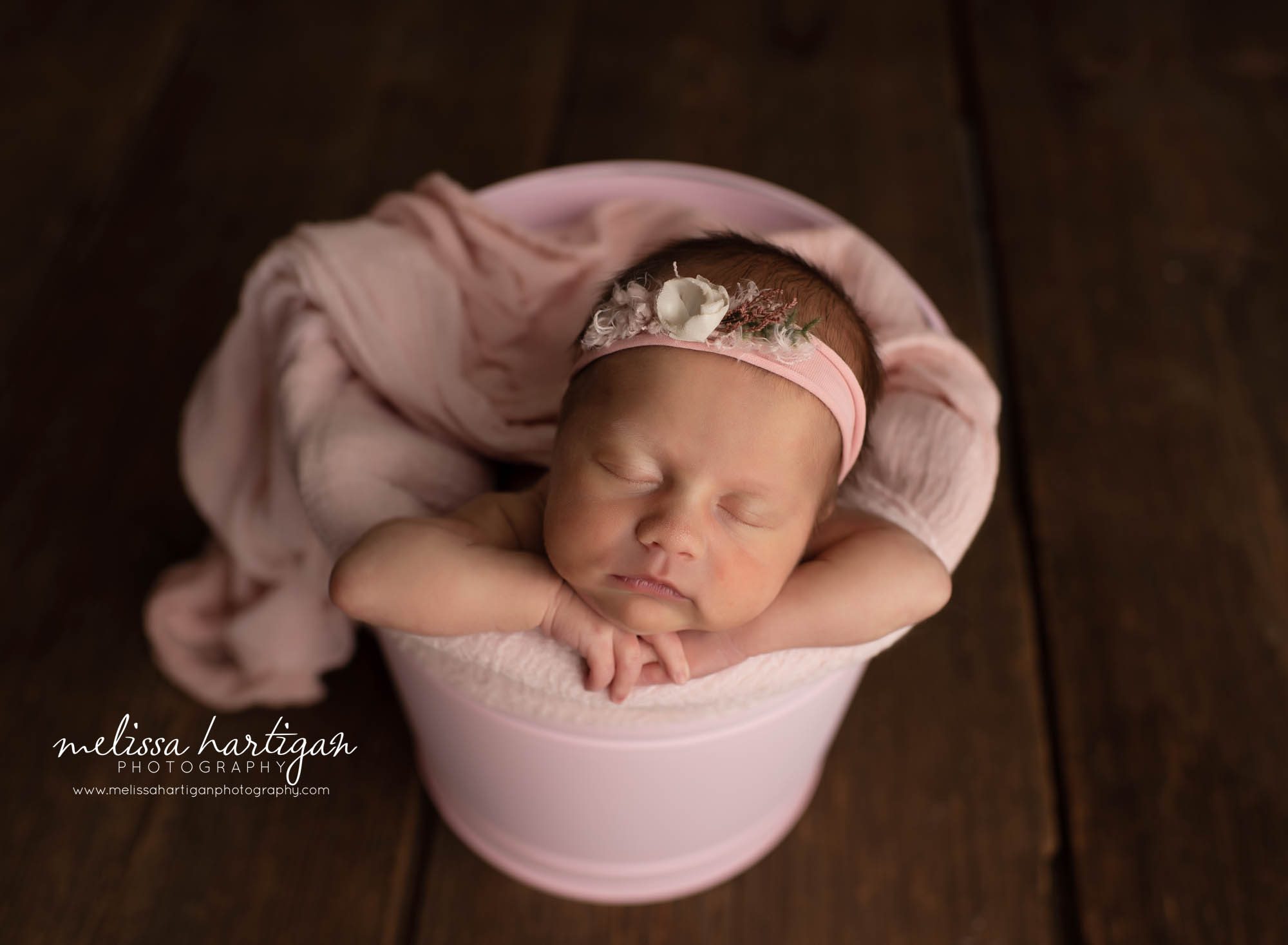 baby girl posed in pink metal bucket with pink wrap CT newborn photograher