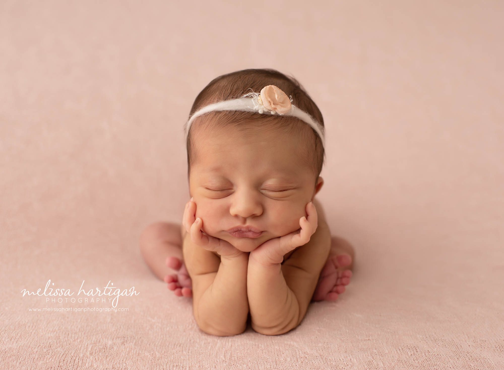 baby girl posed froggy posed on light peach backdrop and flower tieback Vernon CT Newborn Photographer