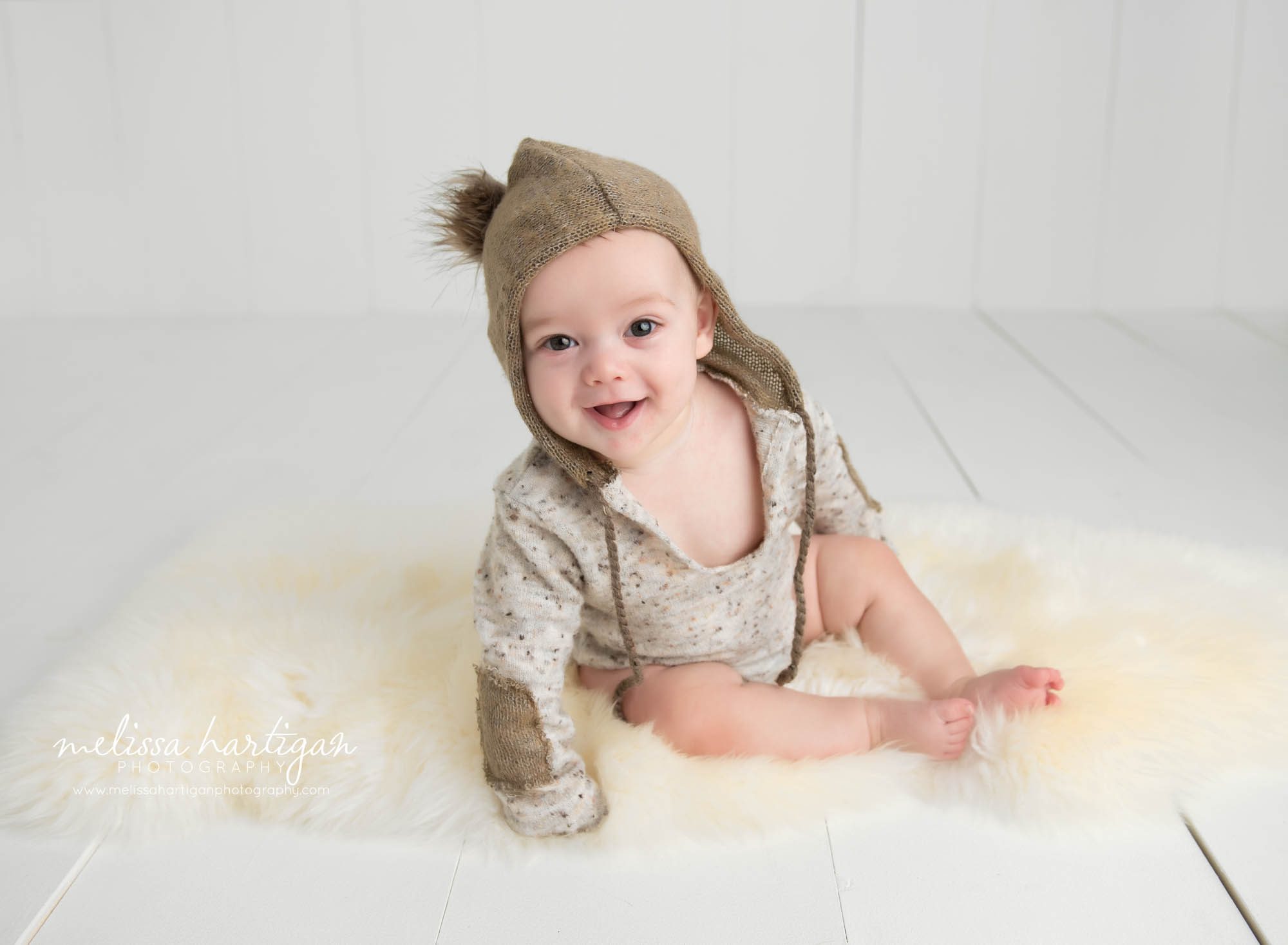 baby boy sitting on cream furry rug in studio photo session Tolland CT Baby Photography
