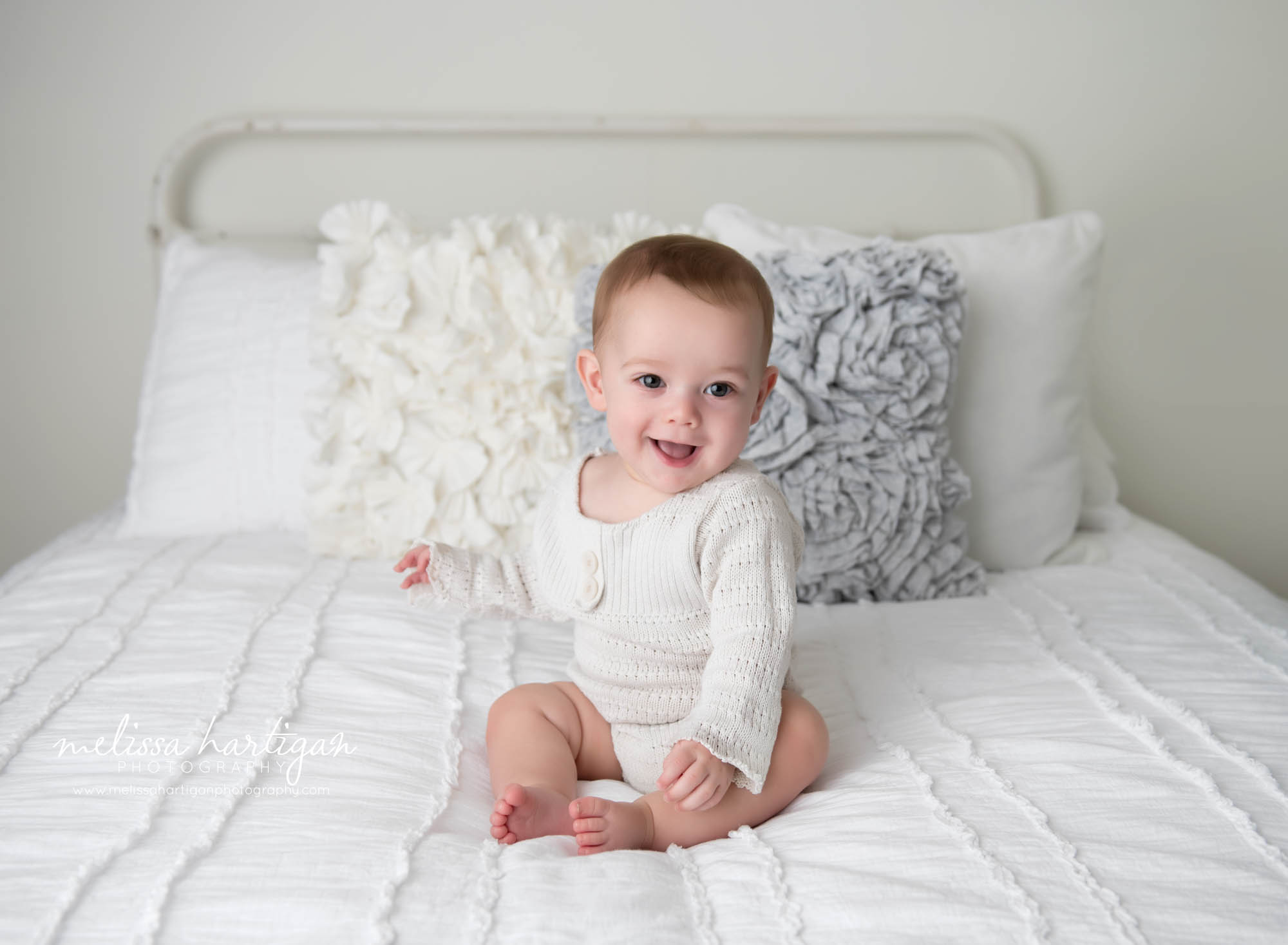 baby boy sitting on white bed in studio photo session Tolland CT Baby Photography