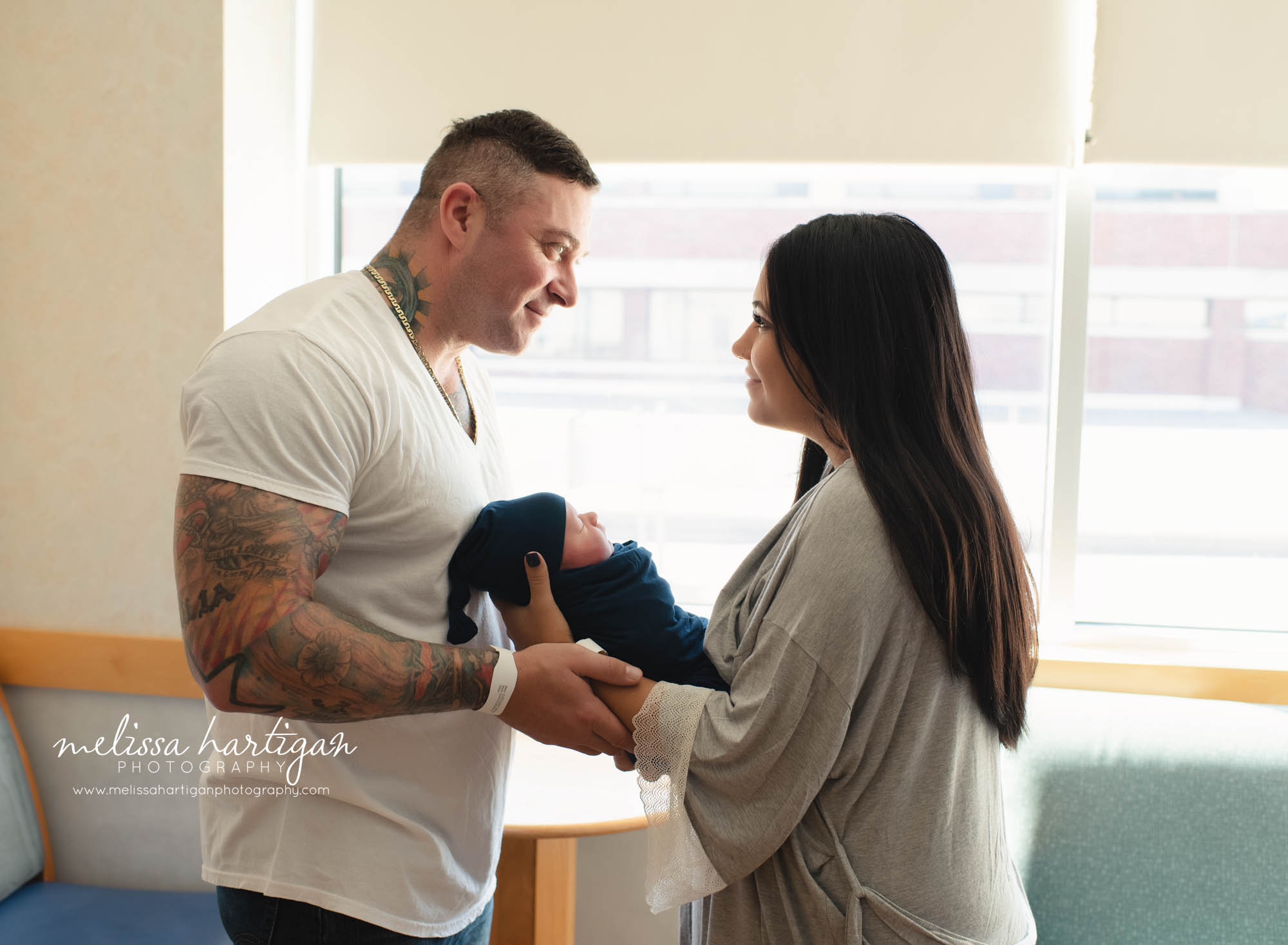 parents holding their newborn son in hospital room manchester ct hospital baby photographer