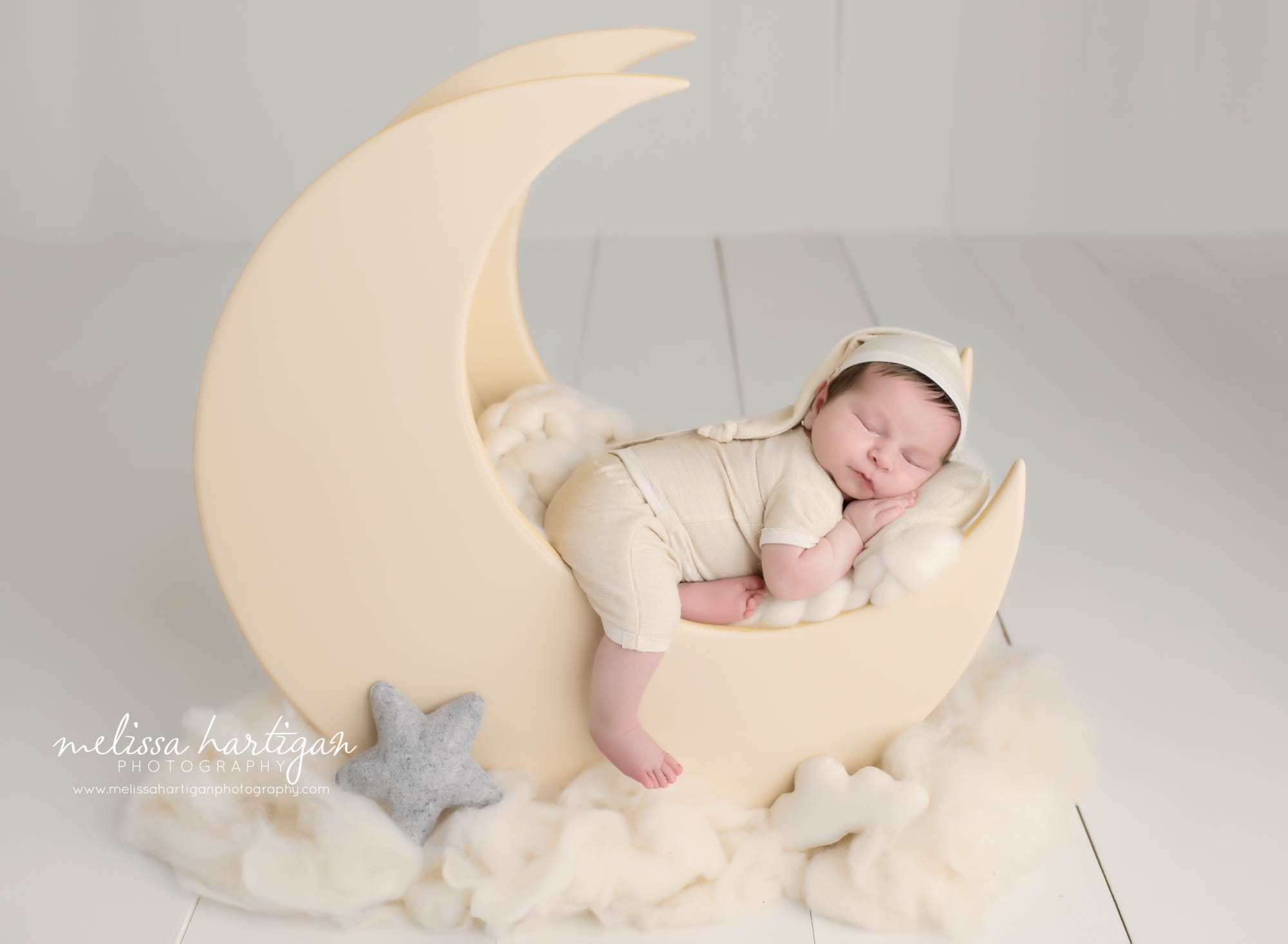 newborn baby boy sleeping on wooden moon prop posed newborn photography session in CT