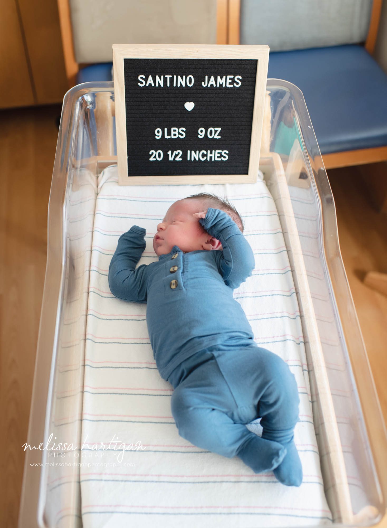 baby boy laying in hospital bassinet with letter board sign