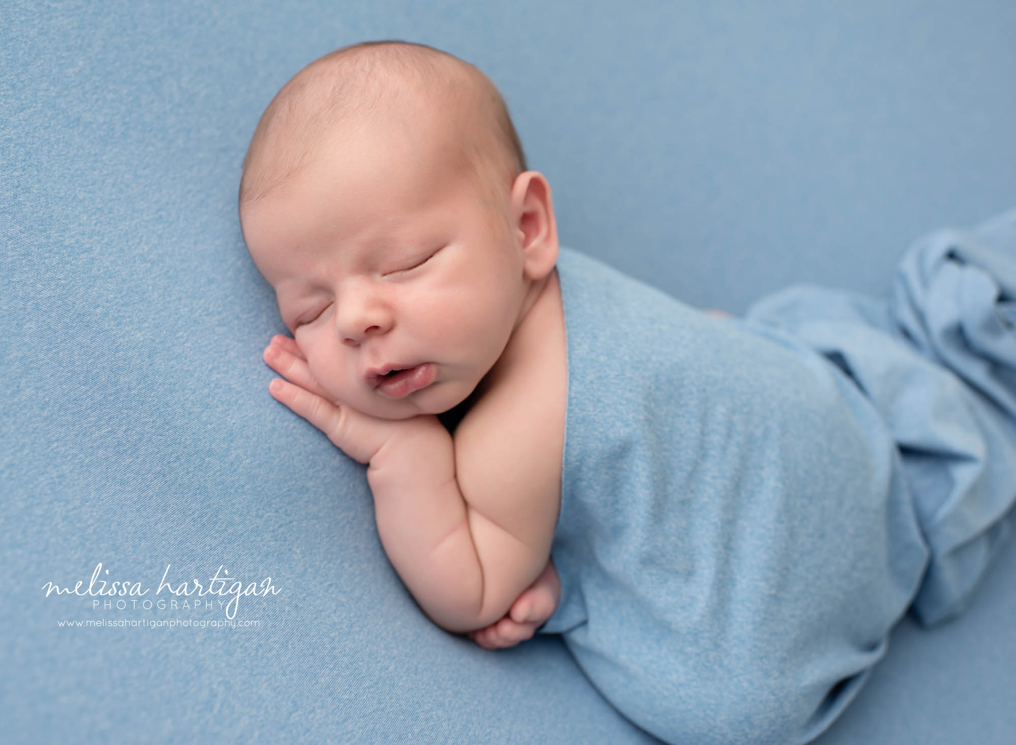 Newborn baby boy posed modified taco pose draped with blue wrap CT newborn photography