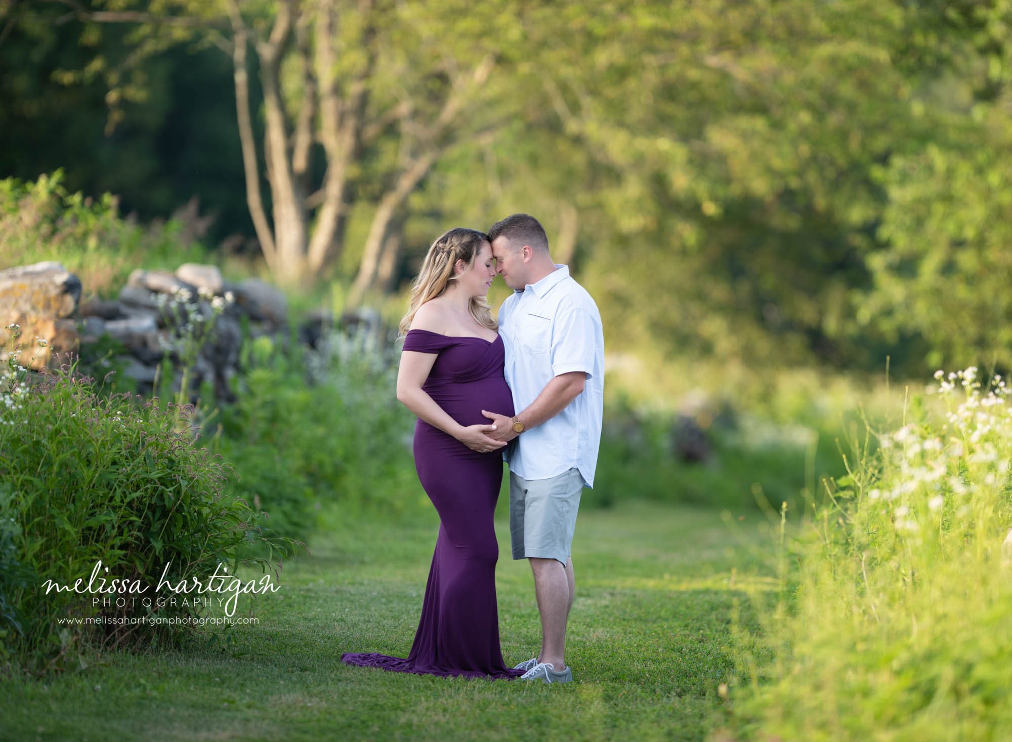 pregnant mom standing in field with dad to be holding baby bump Maternity Photographer CT