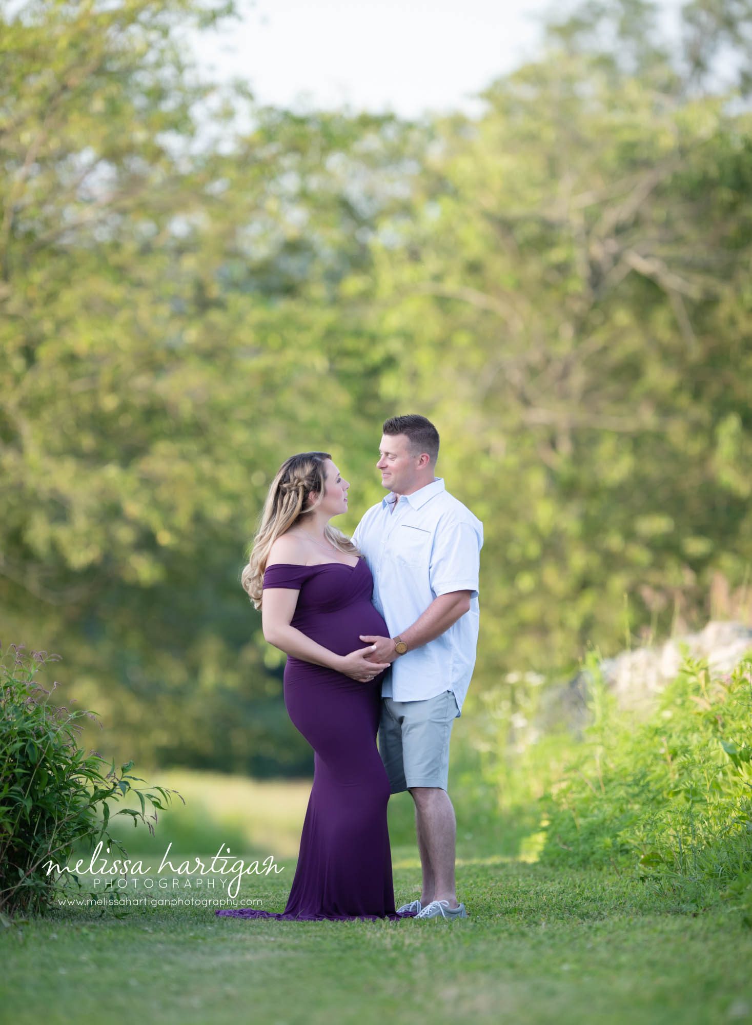 expectant couple standing in field holding baby bump Maternity Photography CT