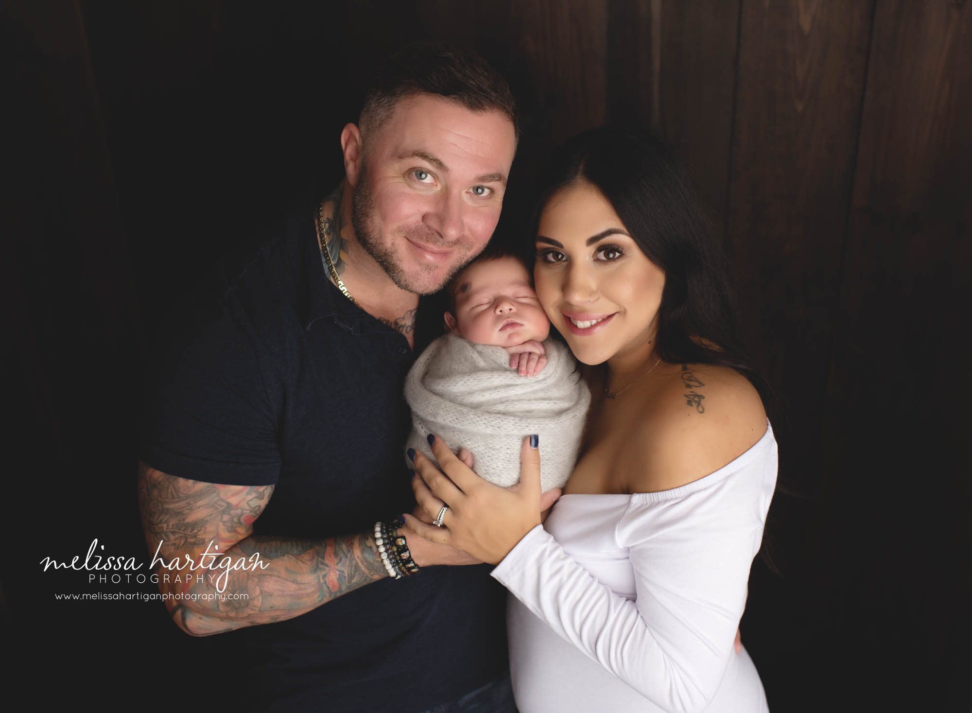 mom and dad and newborn baby boy wrapped in knitted wrap holding newborn son in family picture newborn photography CT