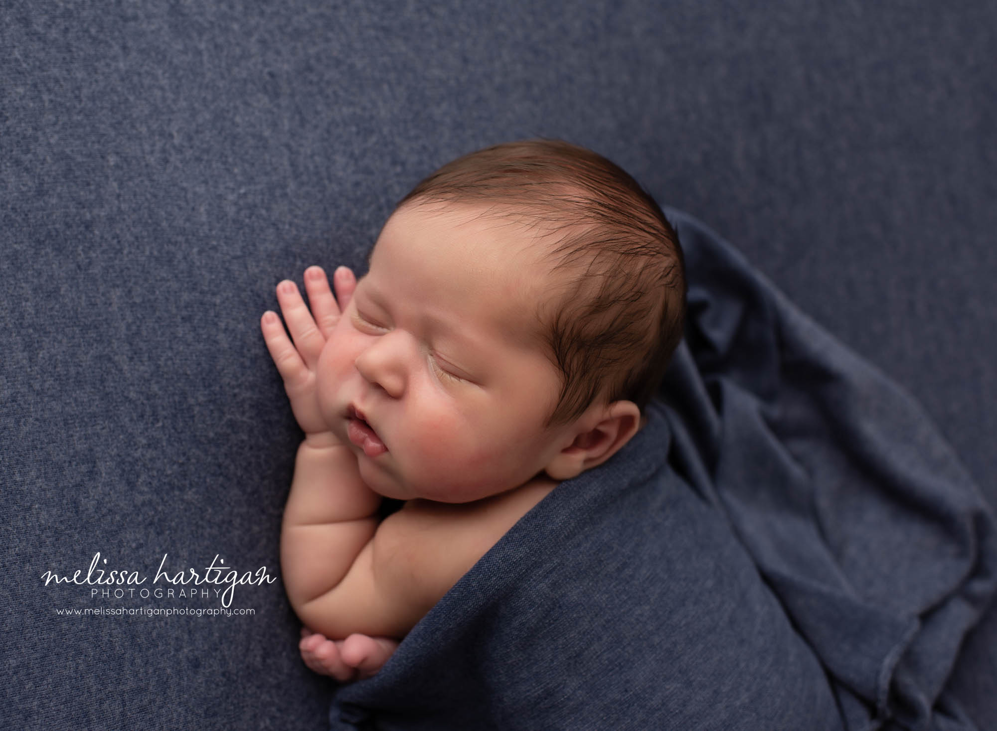 baby bou posed on blue backdrop with blue wrap covering