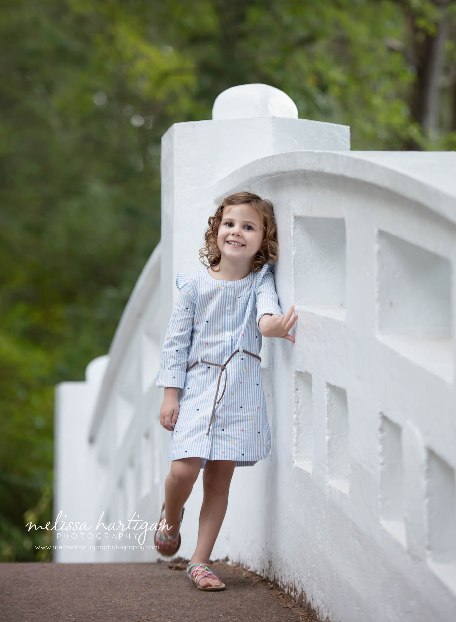 little girl standing on bridge smiling at camera family photo session CT family Photographer