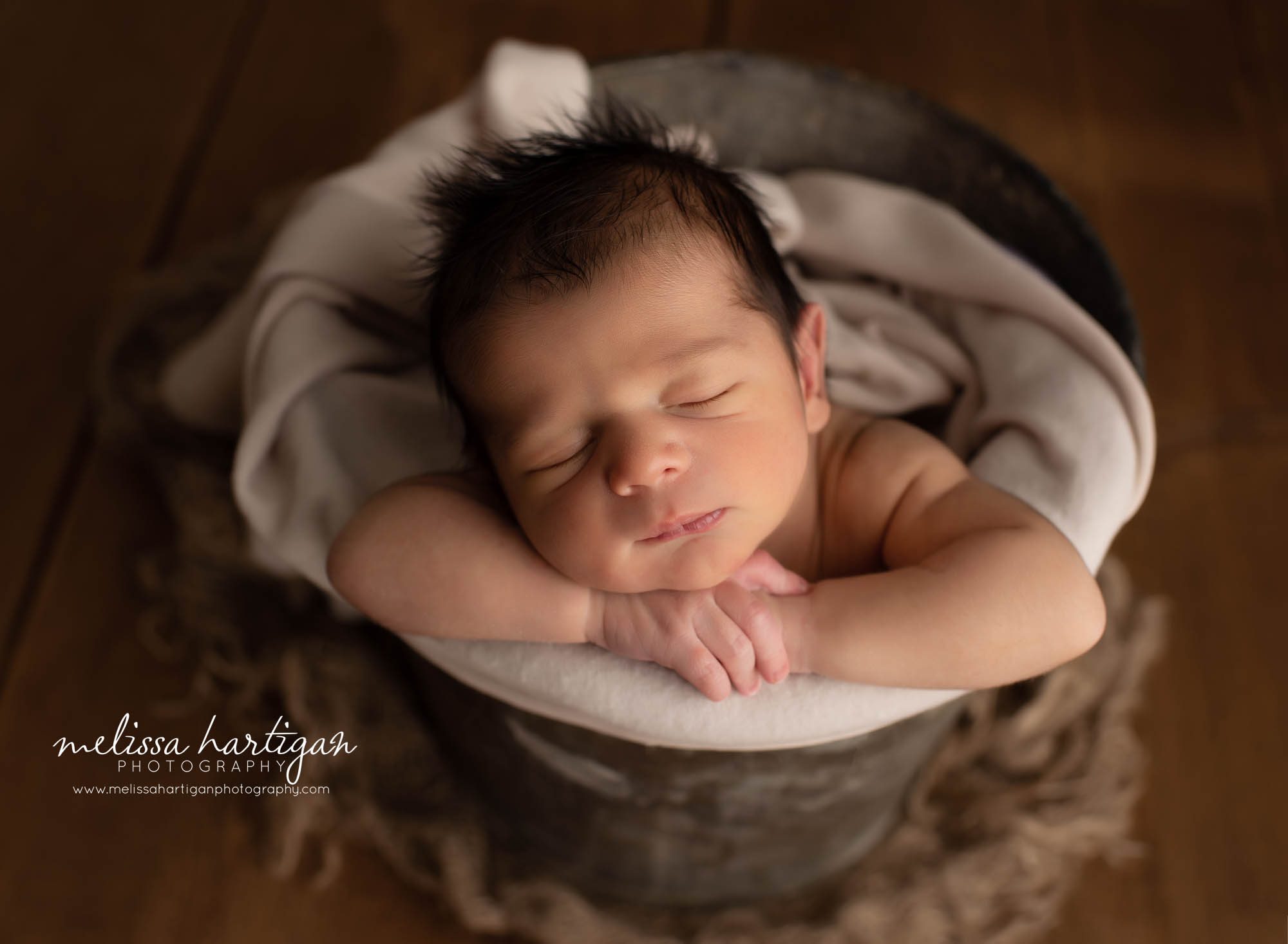 newborn baby boy posed in bucket with neutral color wrap CT newborn photographer