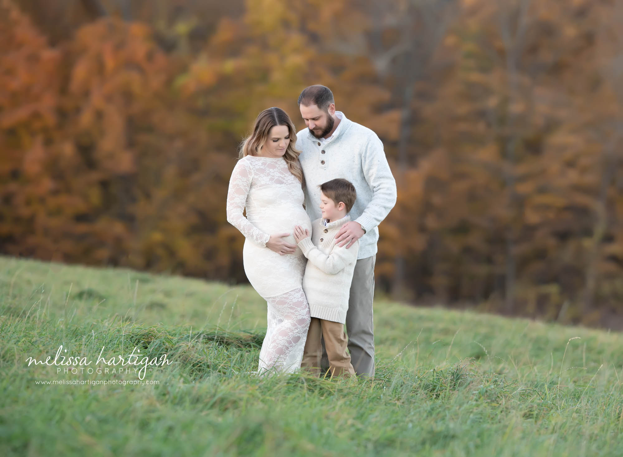 expectant mom and dad with big brother holding moms belly maternity photography session CT