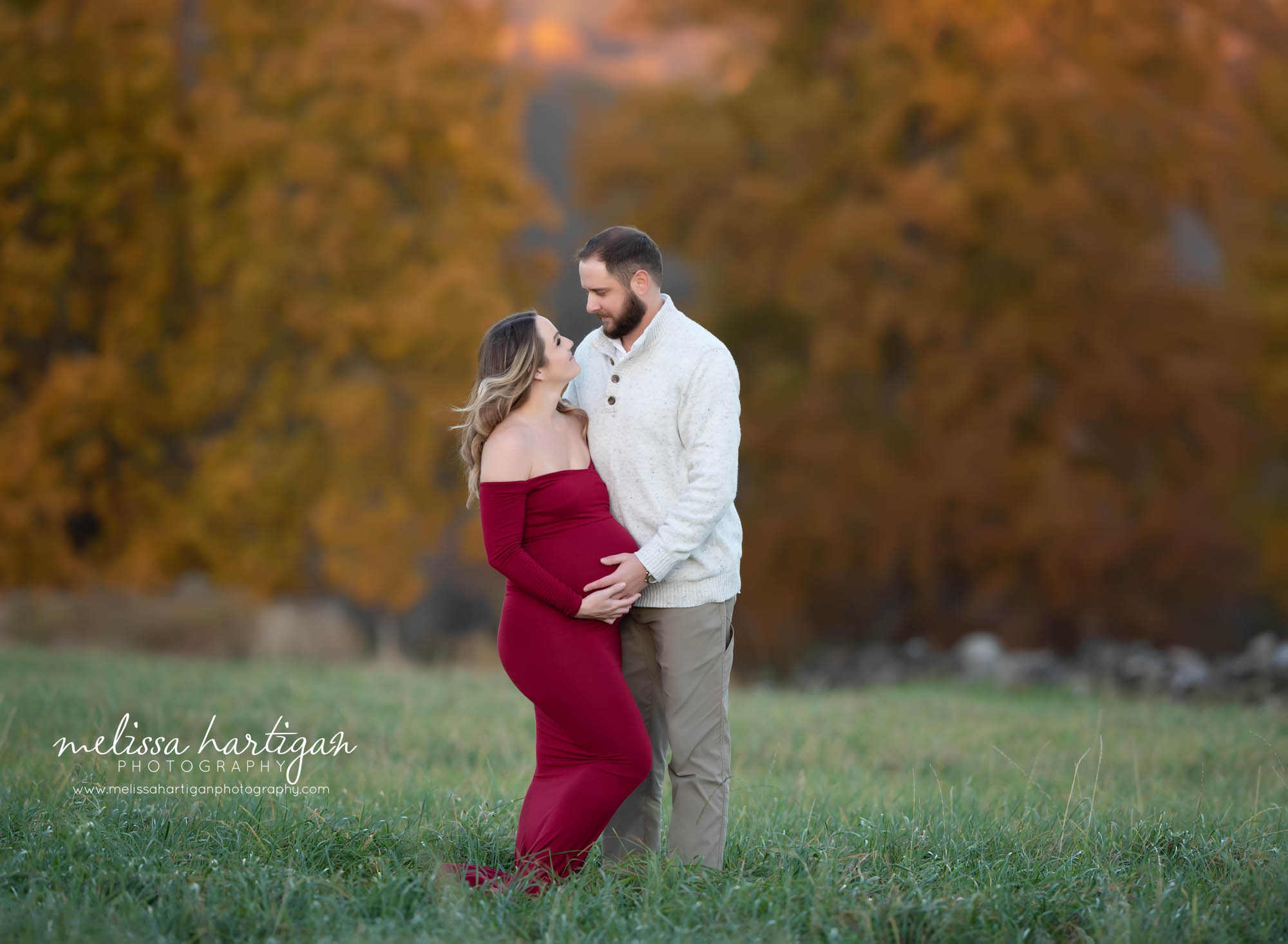 pregnant mom and expectant dad looking at each other holding baby belly CT maternity Photography
