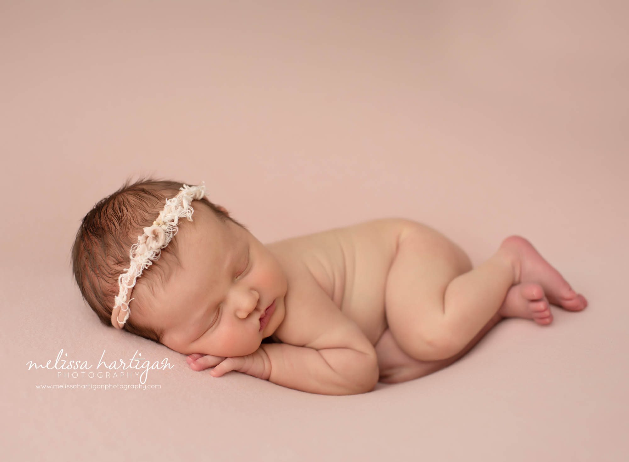 newborn baby girl sleeping posed side with white and cream headband on CT newborn photography session