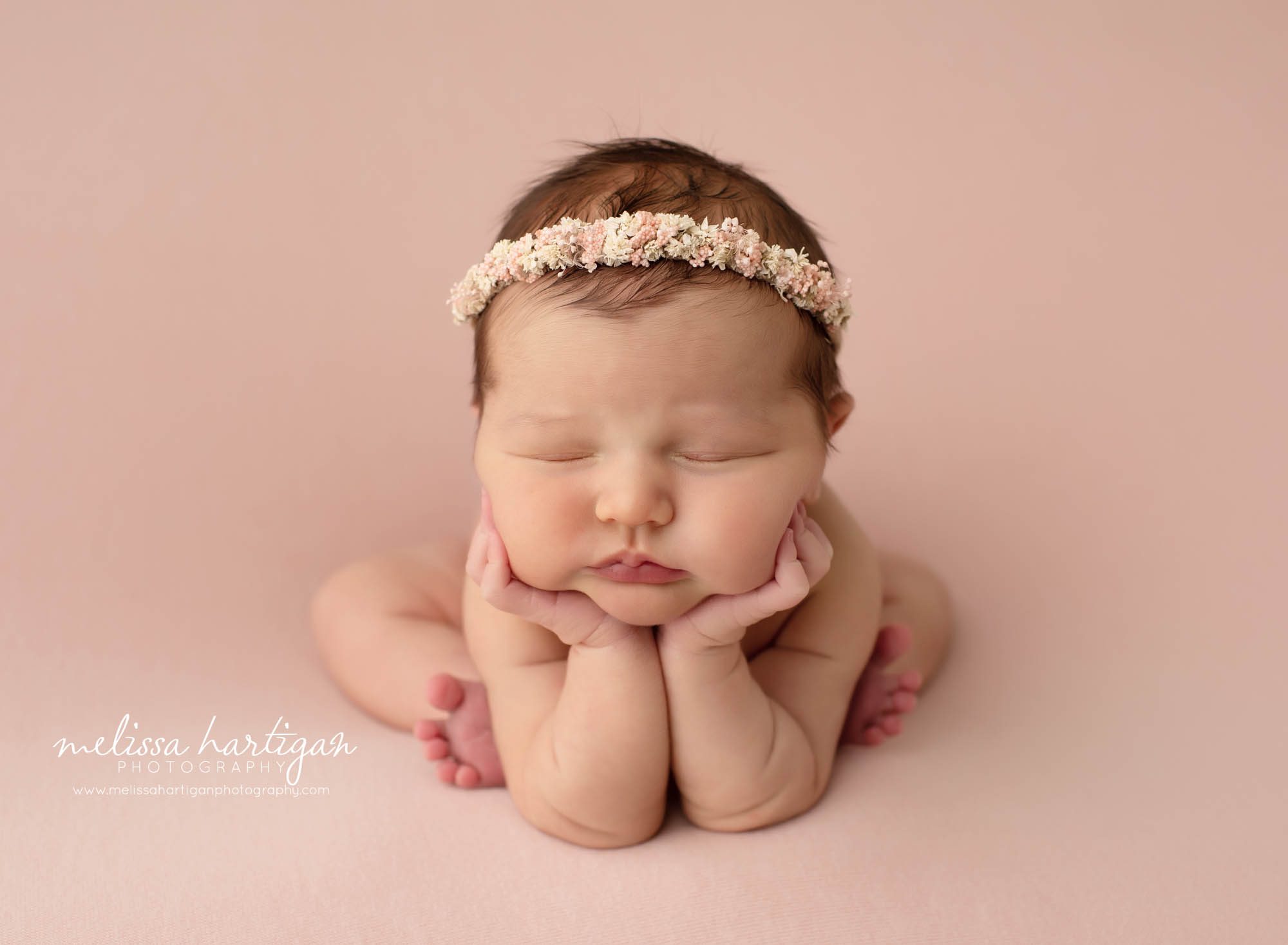 Baby girl posed forggy pose on pink backdrop in newborn photography session