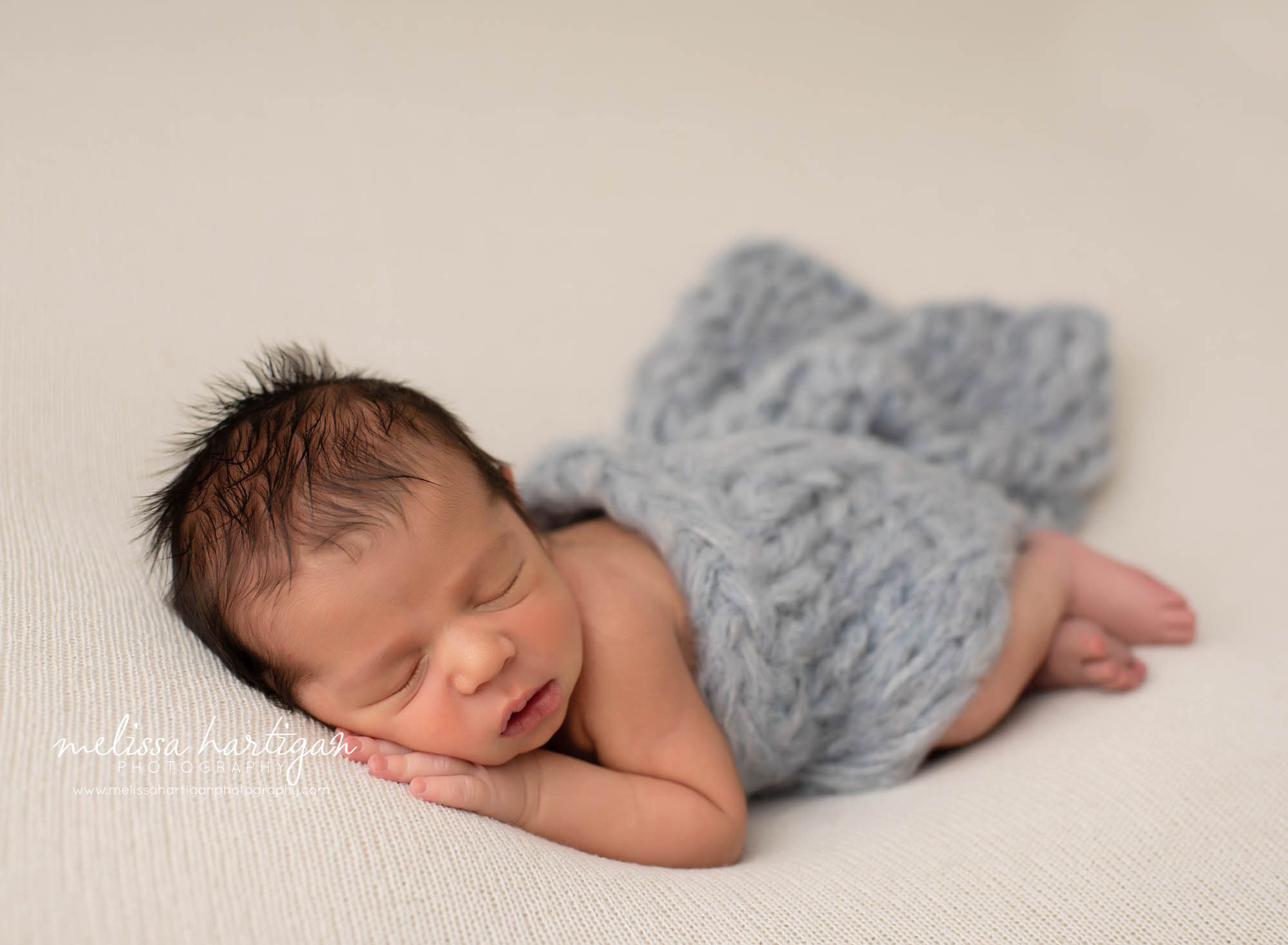 baby boy posed on cream backround with light gray knitted chunky wrap draped over baby boy CT newborn photographer