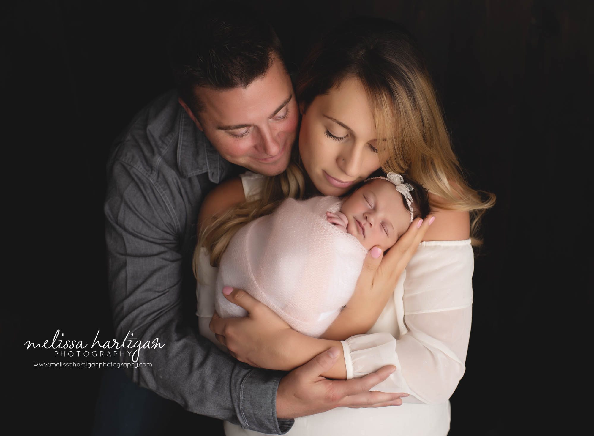 mom dad and holding and snuggling newborn baby girl