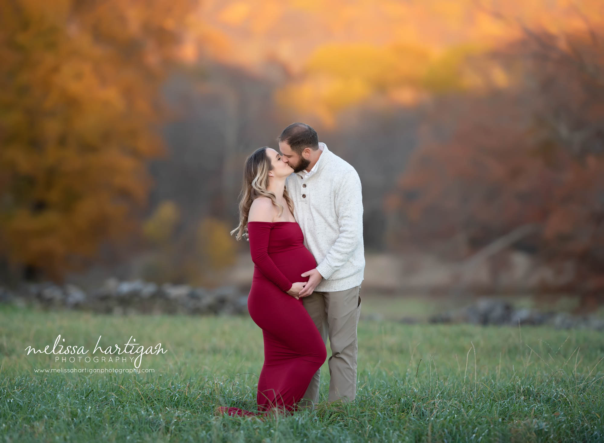 pregnant mom and dad sharing a kiss standing maternity pose outside maternity photography session connecticut