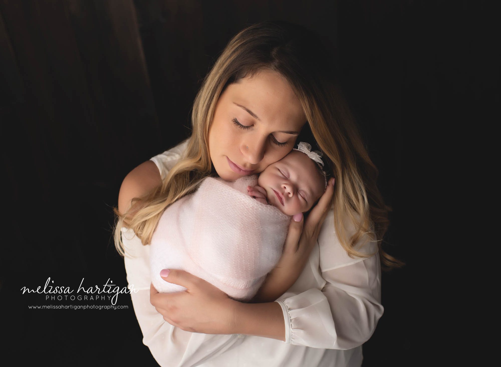 mom holding newborn baby girl in newborn photography studio session