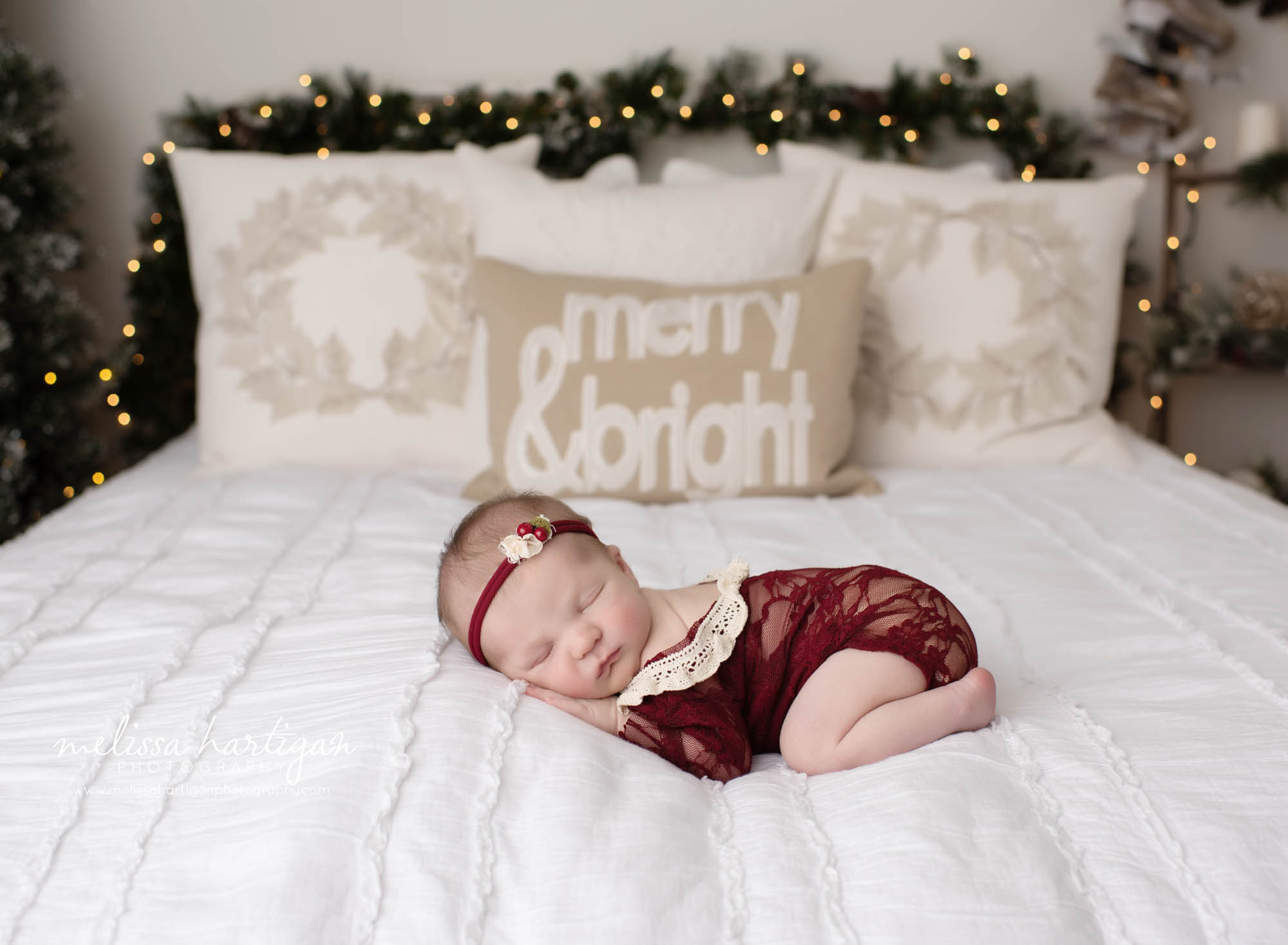 newborn baby girl posed on bed christmas holiday set up