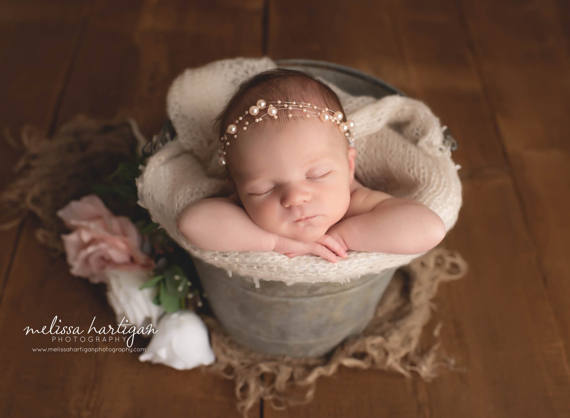 Newborn baby girl posed in bucket with white and pink roses beside bucket Southington CT newborn Photography