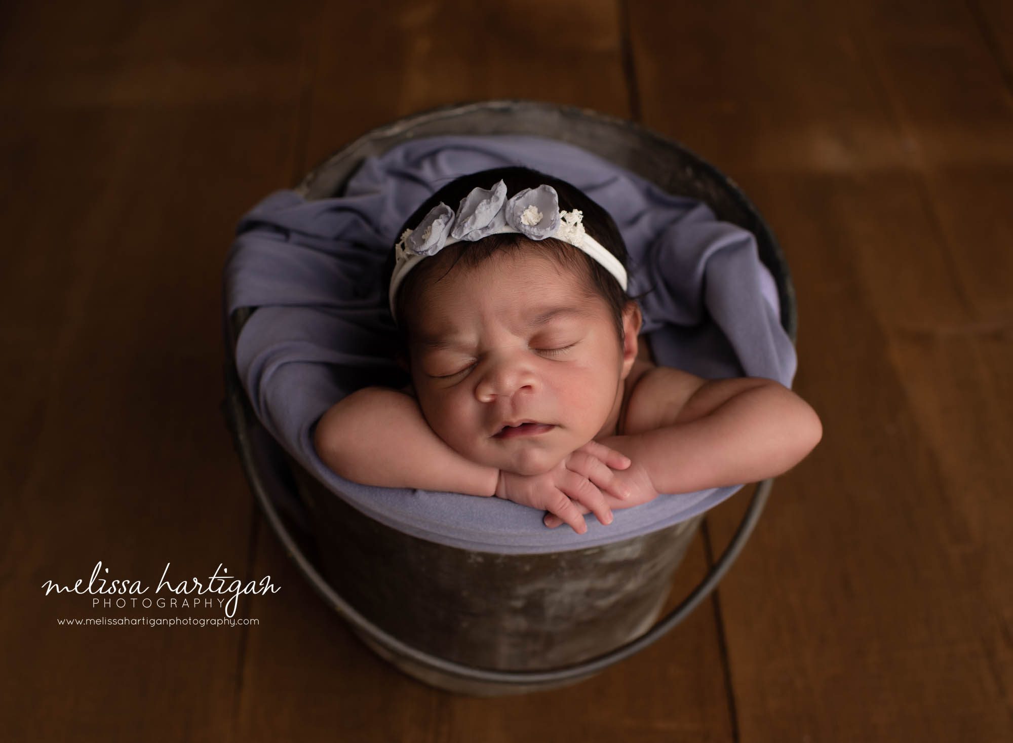 baby girl posed in bucket with purple floral headband