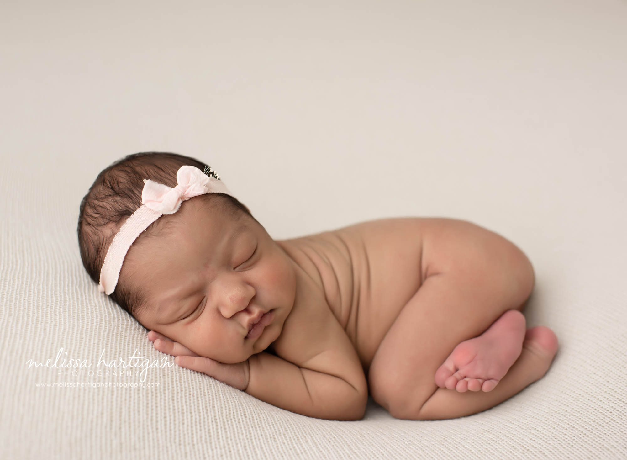 baby girl posed on tummy with light pink bow headband CT newborn Photography