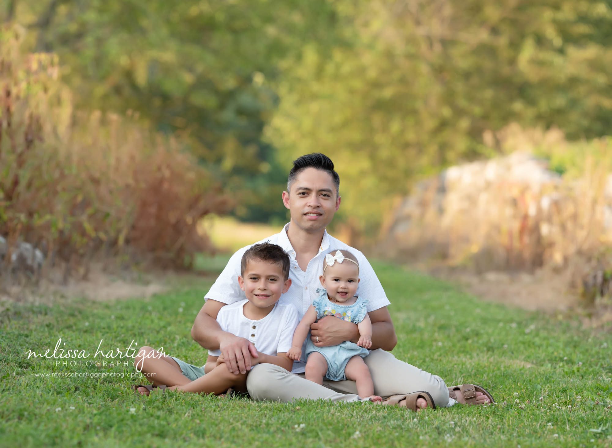 Extended family photography session CT Photographer dad with his two kids outside family session sitting on grass