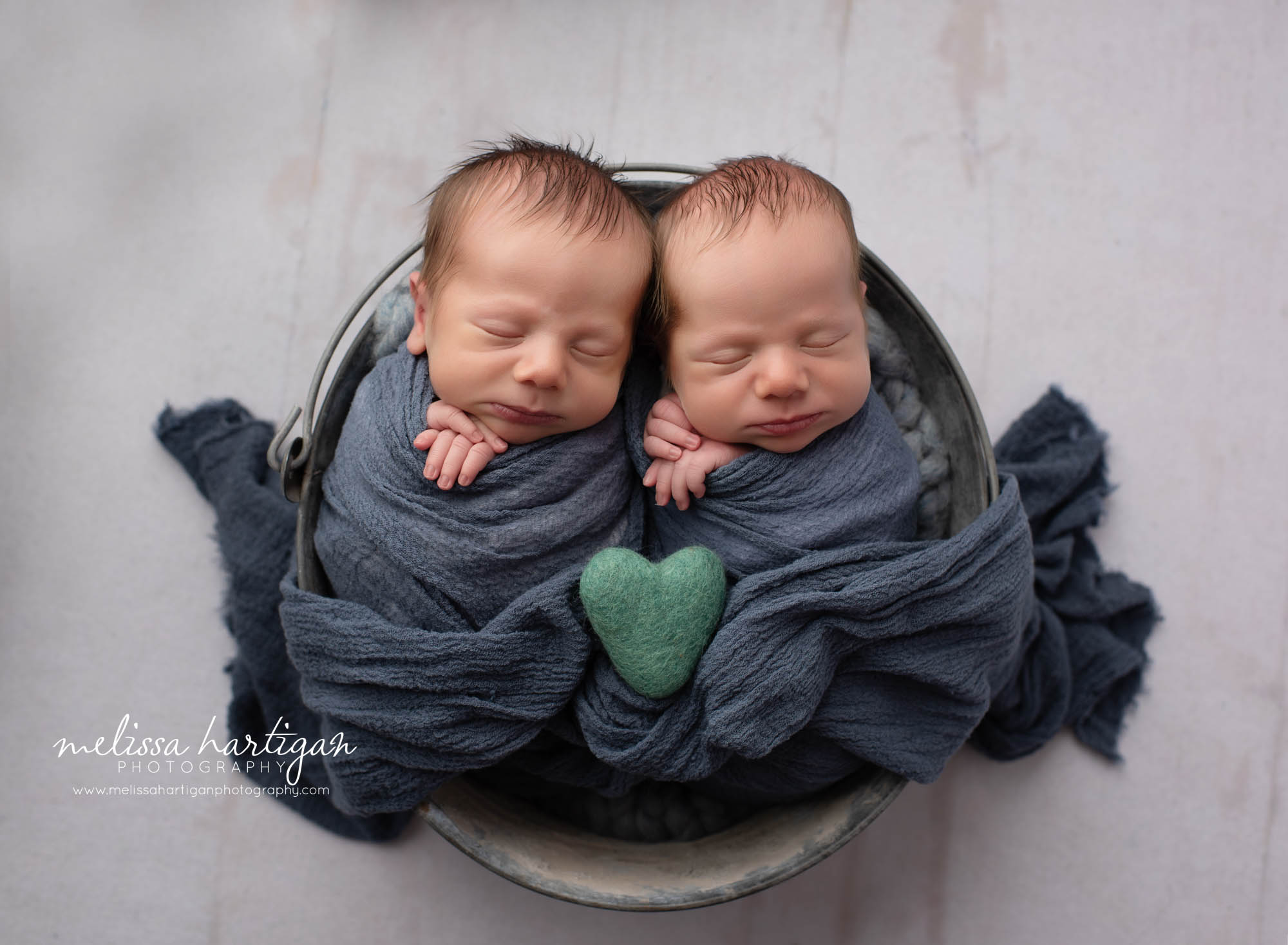 twin boys wraped and posed with green felted heart