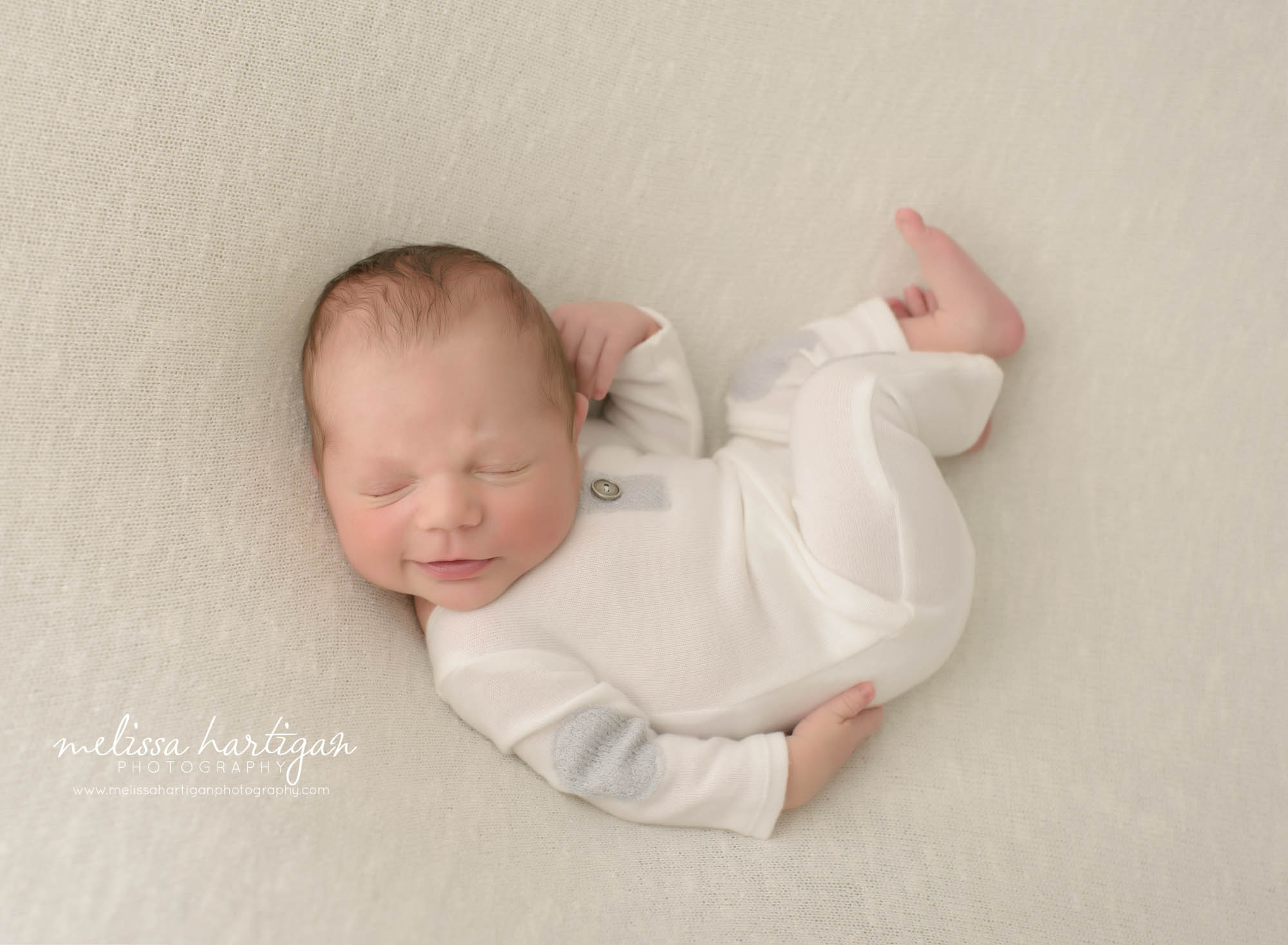 baby boy posed wearing cream colored outfit on posed on light neutral cream ivory backdrop posed newborn photography photo CT newborn Photography East Hartford CT Newborn Photography