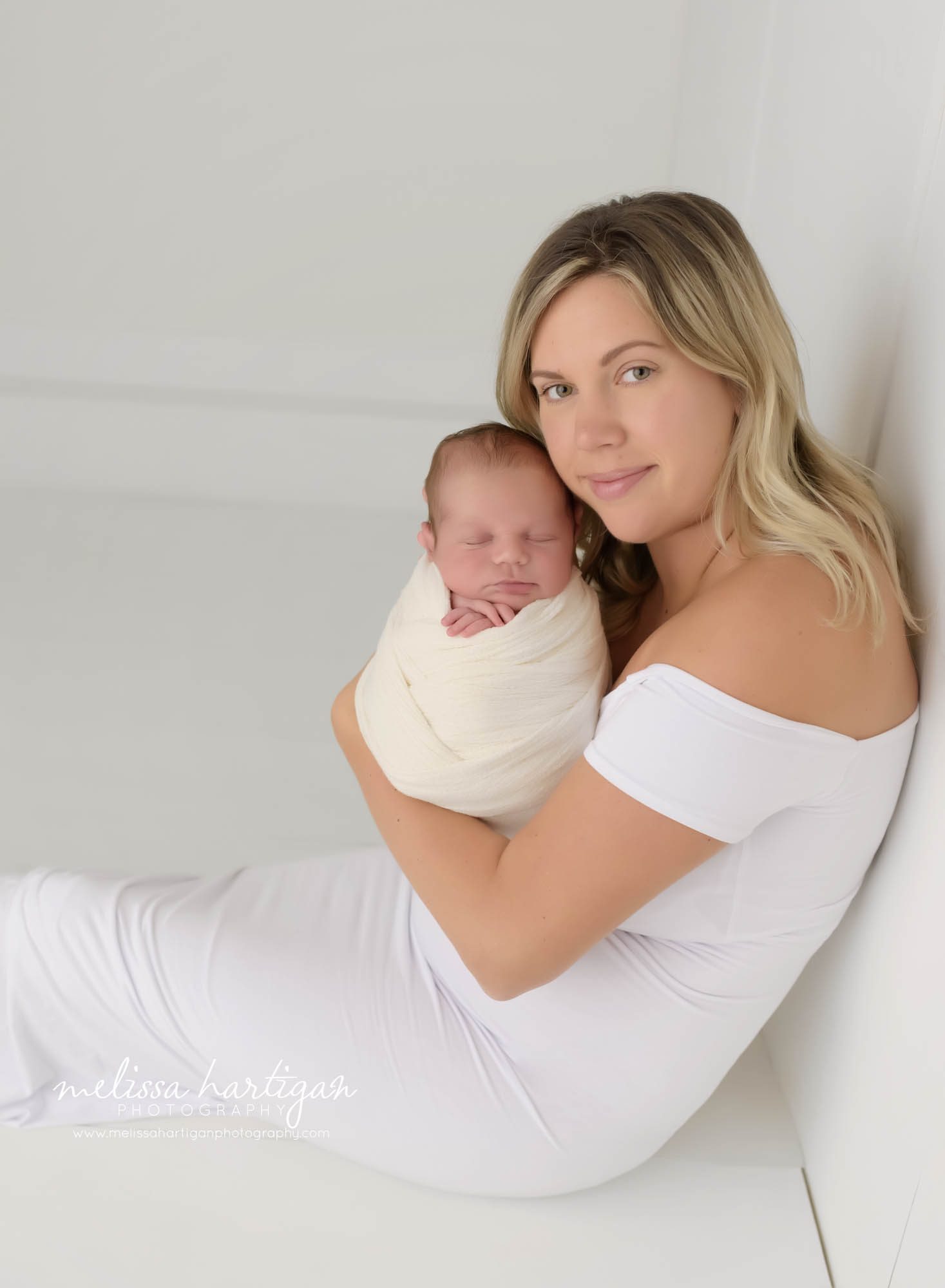 mom holding newborn son up for mom and baby photo pose in newborn photography session